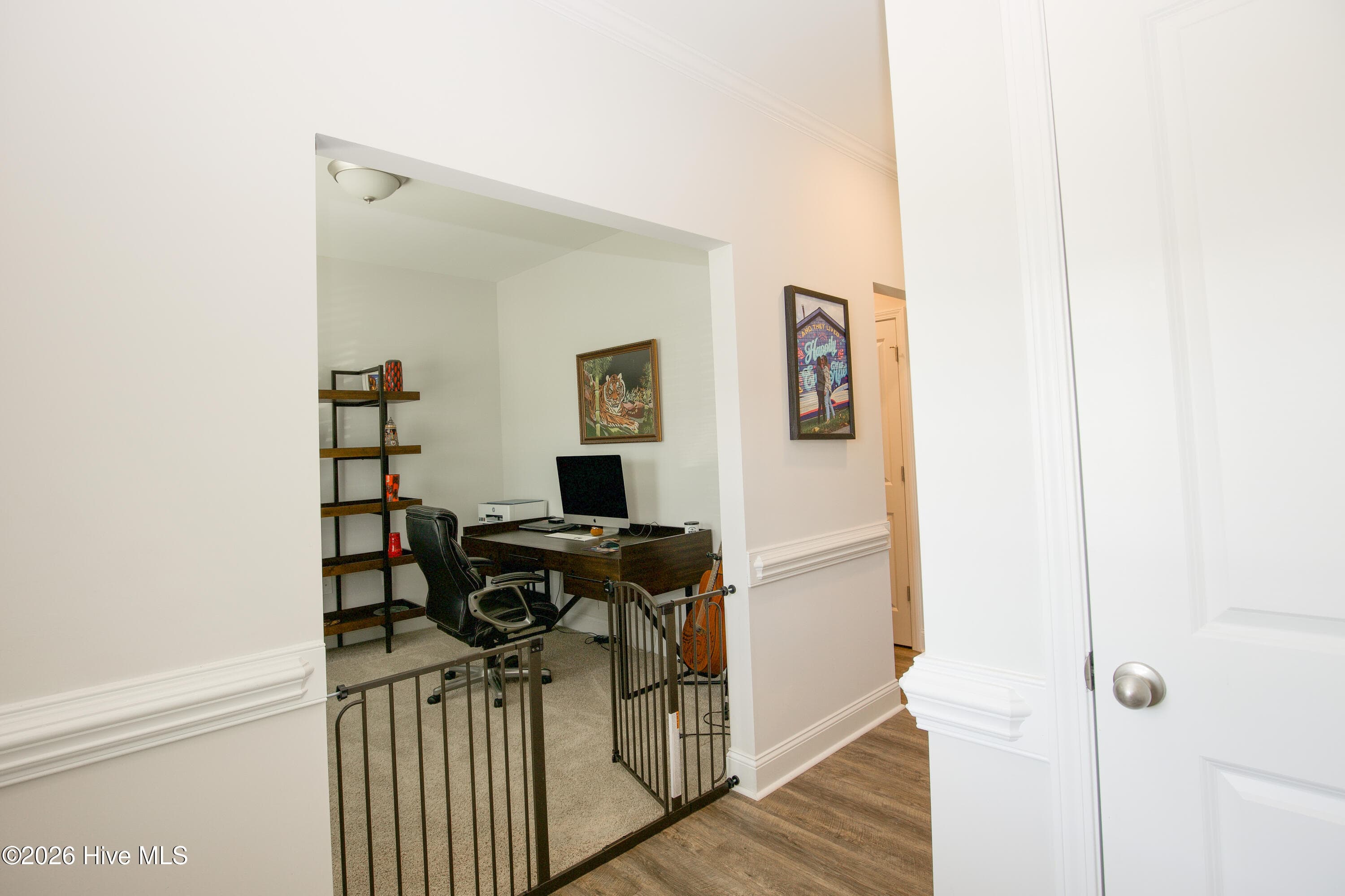 Off the front hall, a wide cased opening leads into the separate flex room, currently set up as a home office. Because it sits near the front entry, the room stays apart from the kitchen and Great Room, which helps if you work from home or want a quieter space. Chair-rail trim continues along the hall outside the room. - 221 Vega Lane, Linden, NC 28356
