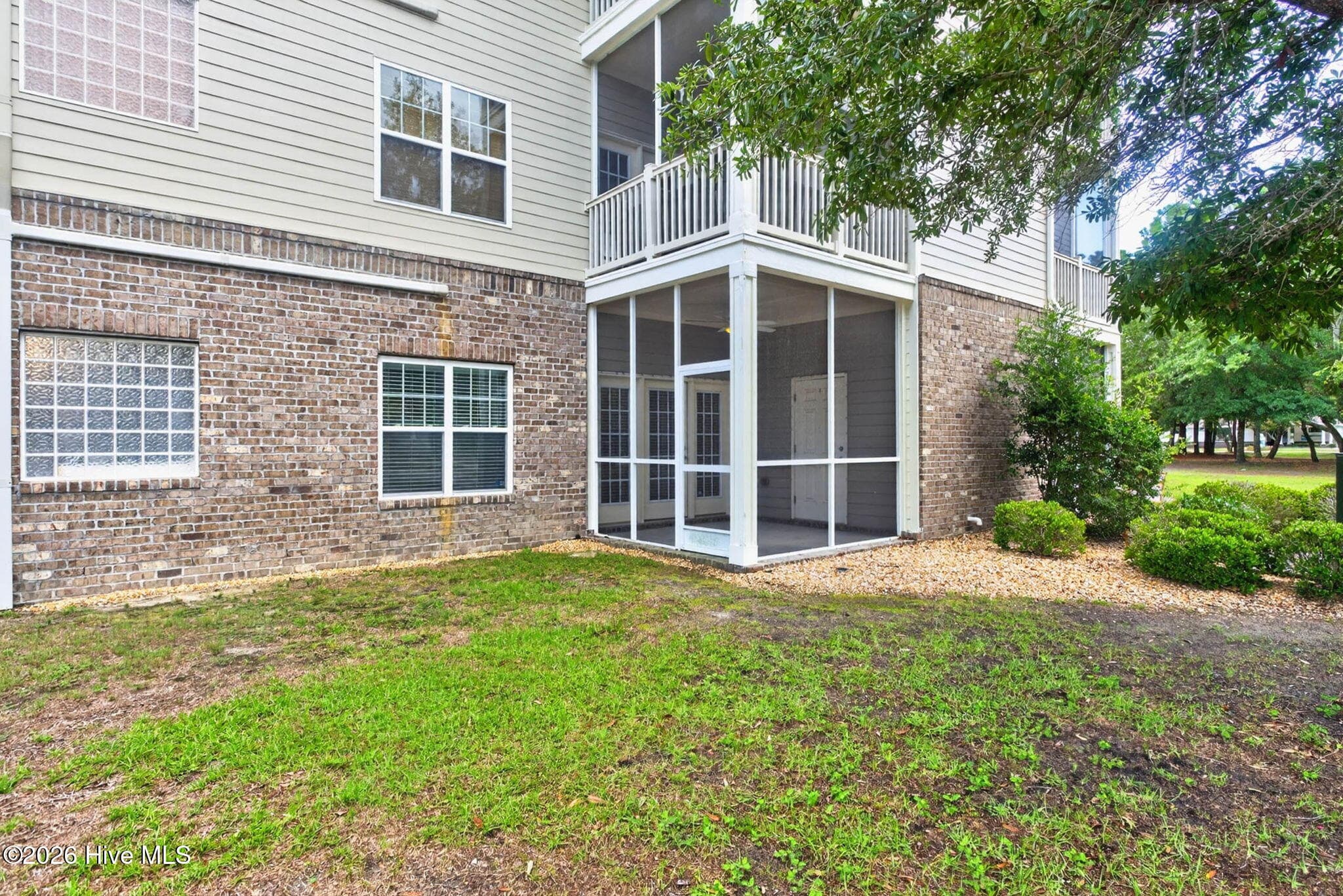 Ground level photo of condo and screened-in porch - 7825 High Market Street #303, Sunset Beach, NC 28468
