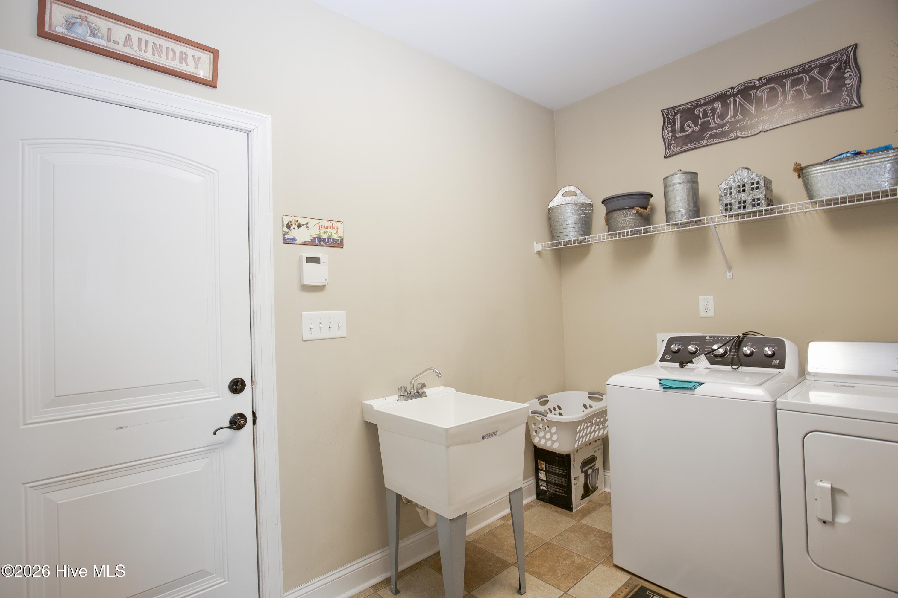 Laundry room with a utility sink and cabinet storage. - 899 Seagull Drive, Vass, NC 28394, Vass