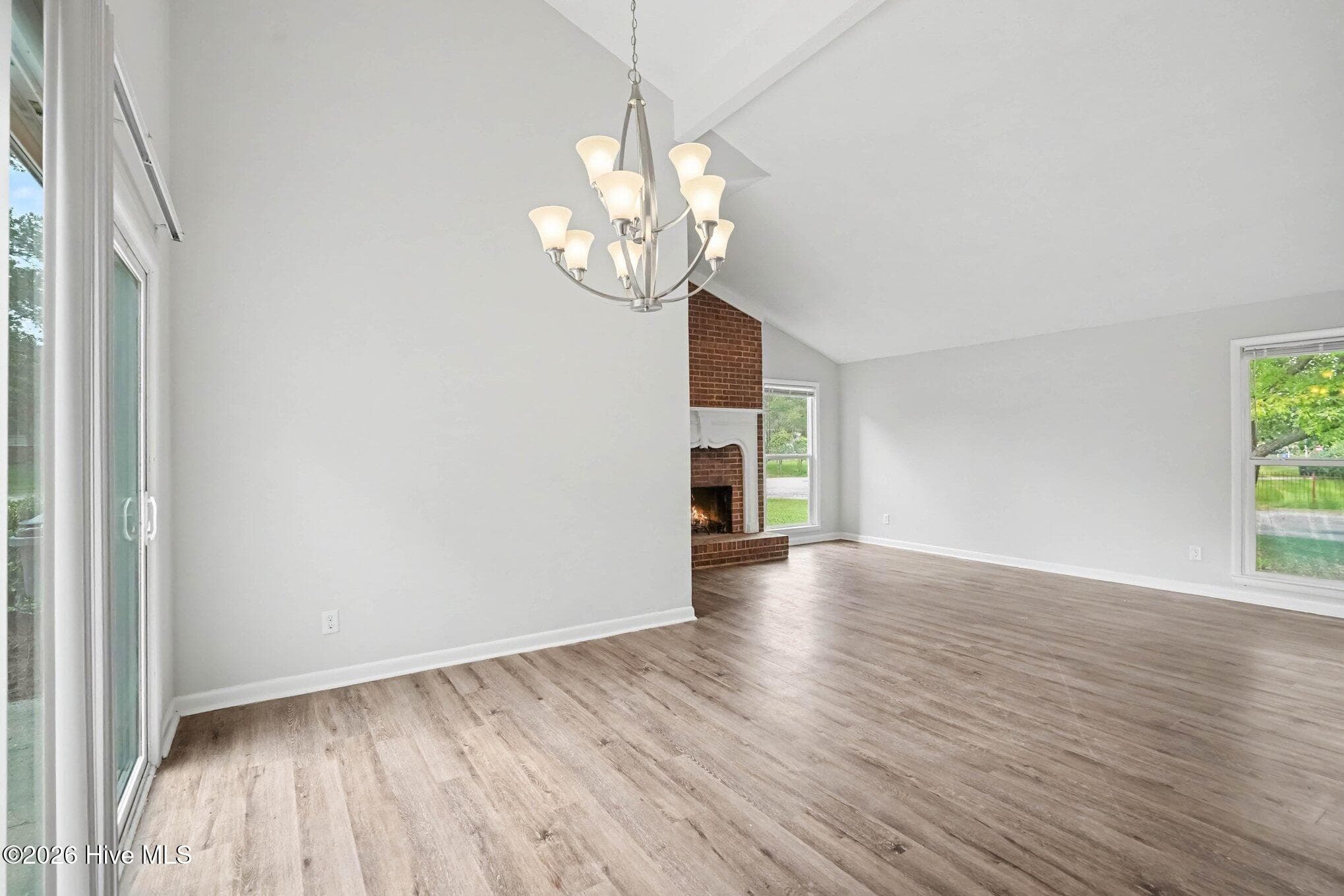 Dedicated dining area illuminated by a classic chandelier, featuring sliding glass door for loads of natural light and views of the side yard as well as open sightlines to the main living space. - 108 Deerfield Drive, Spring Lake, NC 28390
