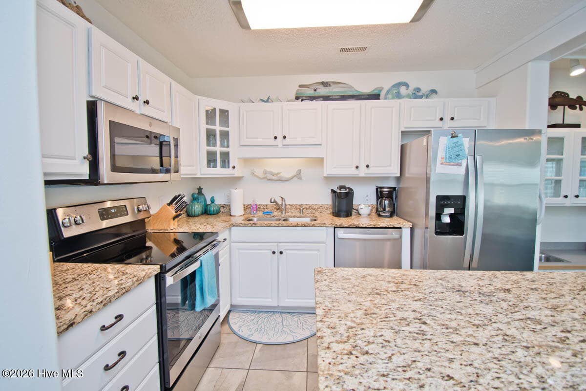 The kitchen is equipped with granite countertops, adding both style and durability for everyday living or rental guests. - 2909 Pointe West Drive 3b1, Emerald Isle, NC 28594