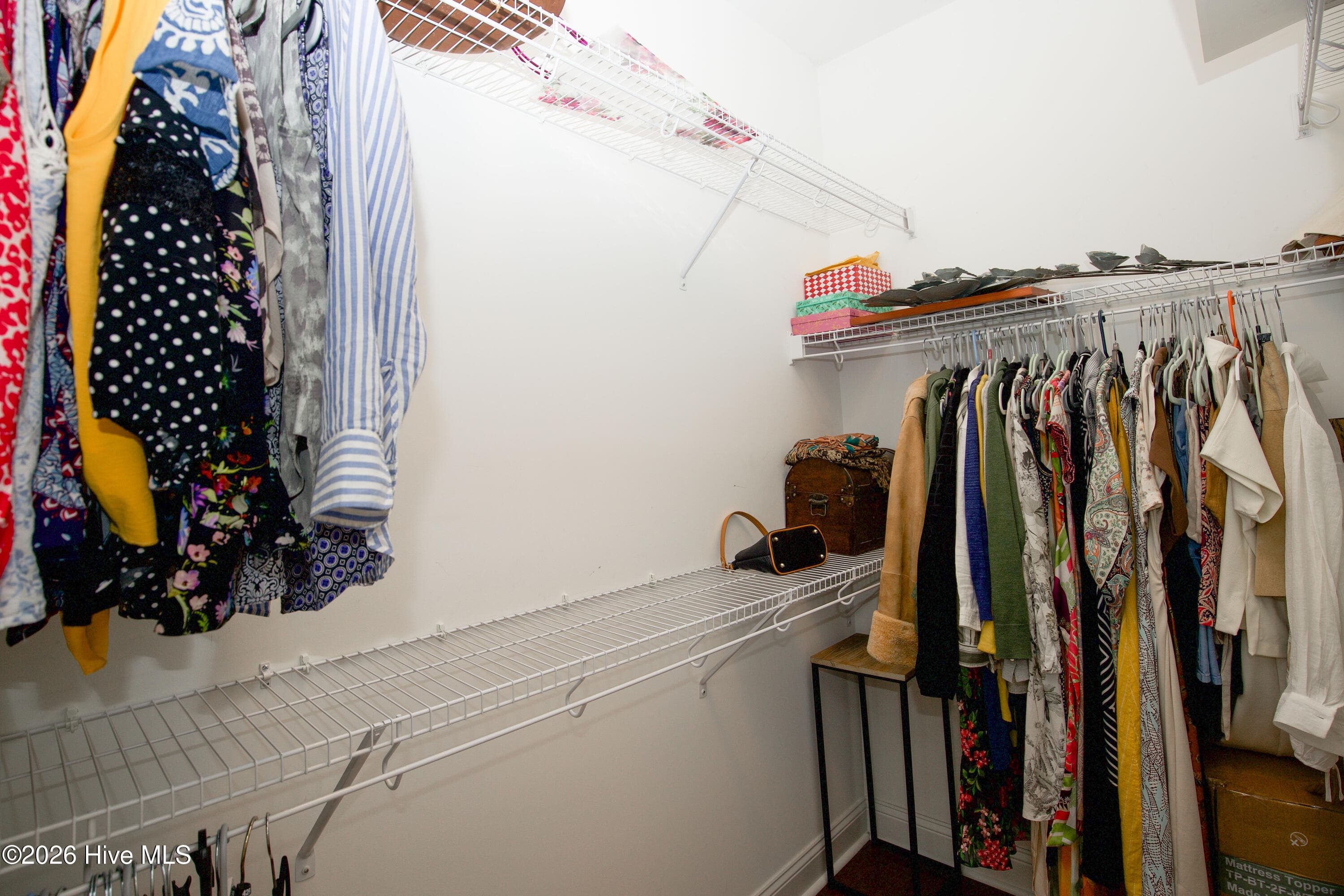 Walk-in closet in the primary suite with shelving on two walls. - 899 Seagull Drive, Vass, NC 28394, Vass