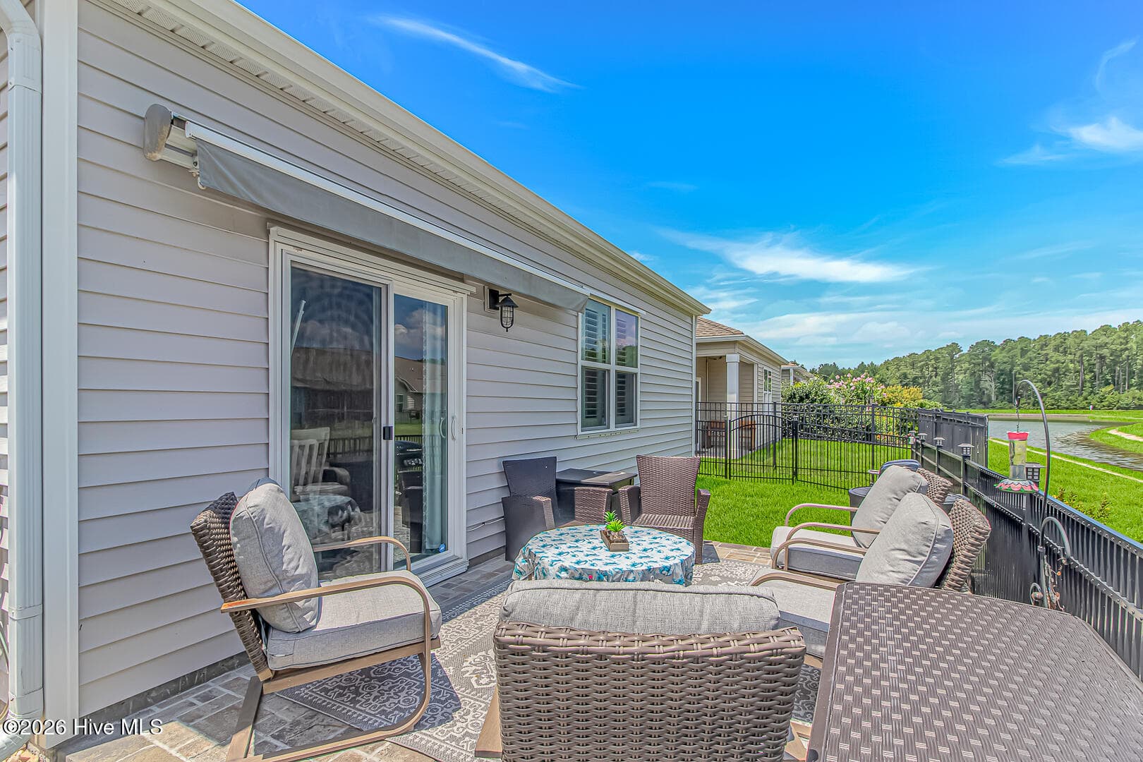 Oversized paver patio off dining room. Fully automatic awning with fully retractable wind sensor - 27 Cattle Run Lane, Carolina Shores, NC 28467