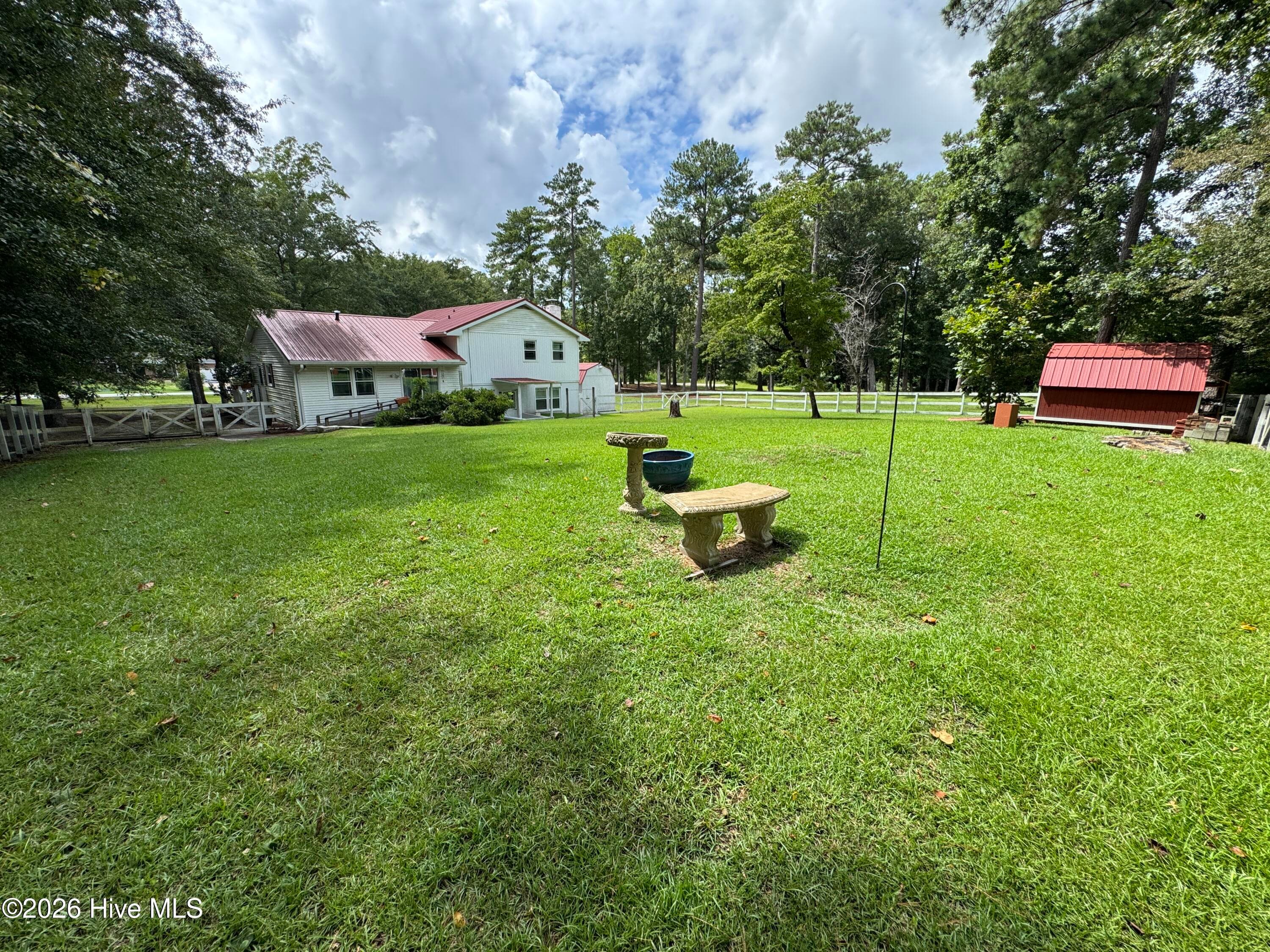 Imagine sitting on this bench, watching wild turkey or deer amble across the yard. So peaceful! - 118 Oakwood Drive, Havelock, NC 28532