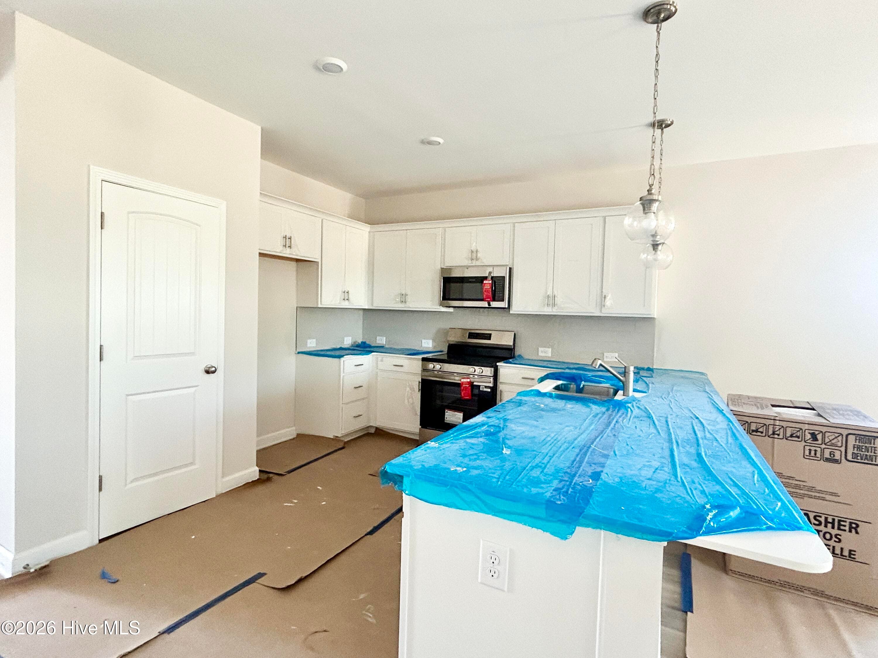 Elegant Kitchen includes Quartz Countertops, Stainless Appliances, Tile Backsplash, and Beautiful Lighting fixtures. - 4192 Workman Loop 90, Leland, NC 28451