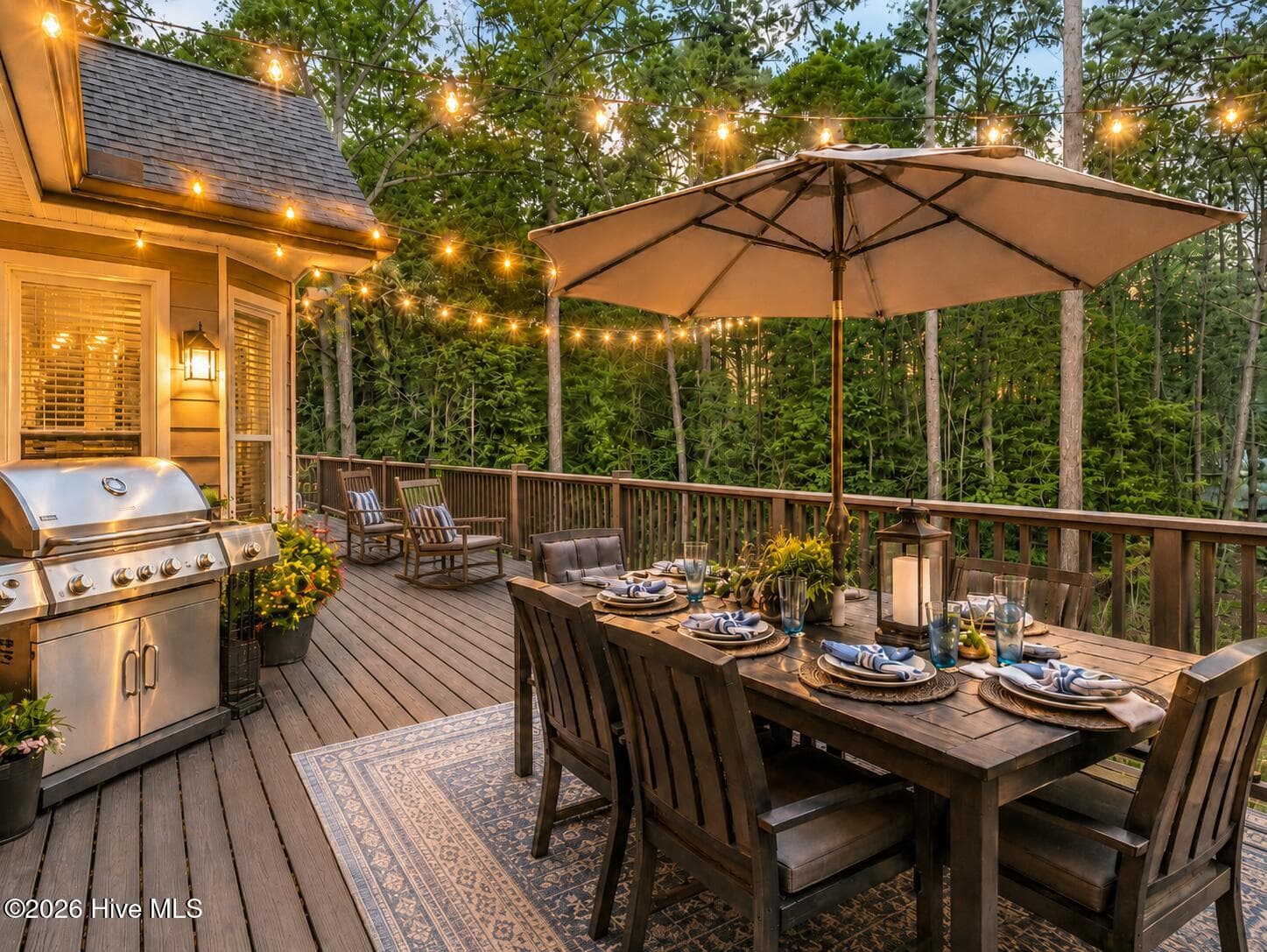 An inviting back deck made for outdoor living, with dining space, grilling, rocking chairs, and peaceful wooded views all around. - 16 Rapids Court, North Augusta, SC 29841