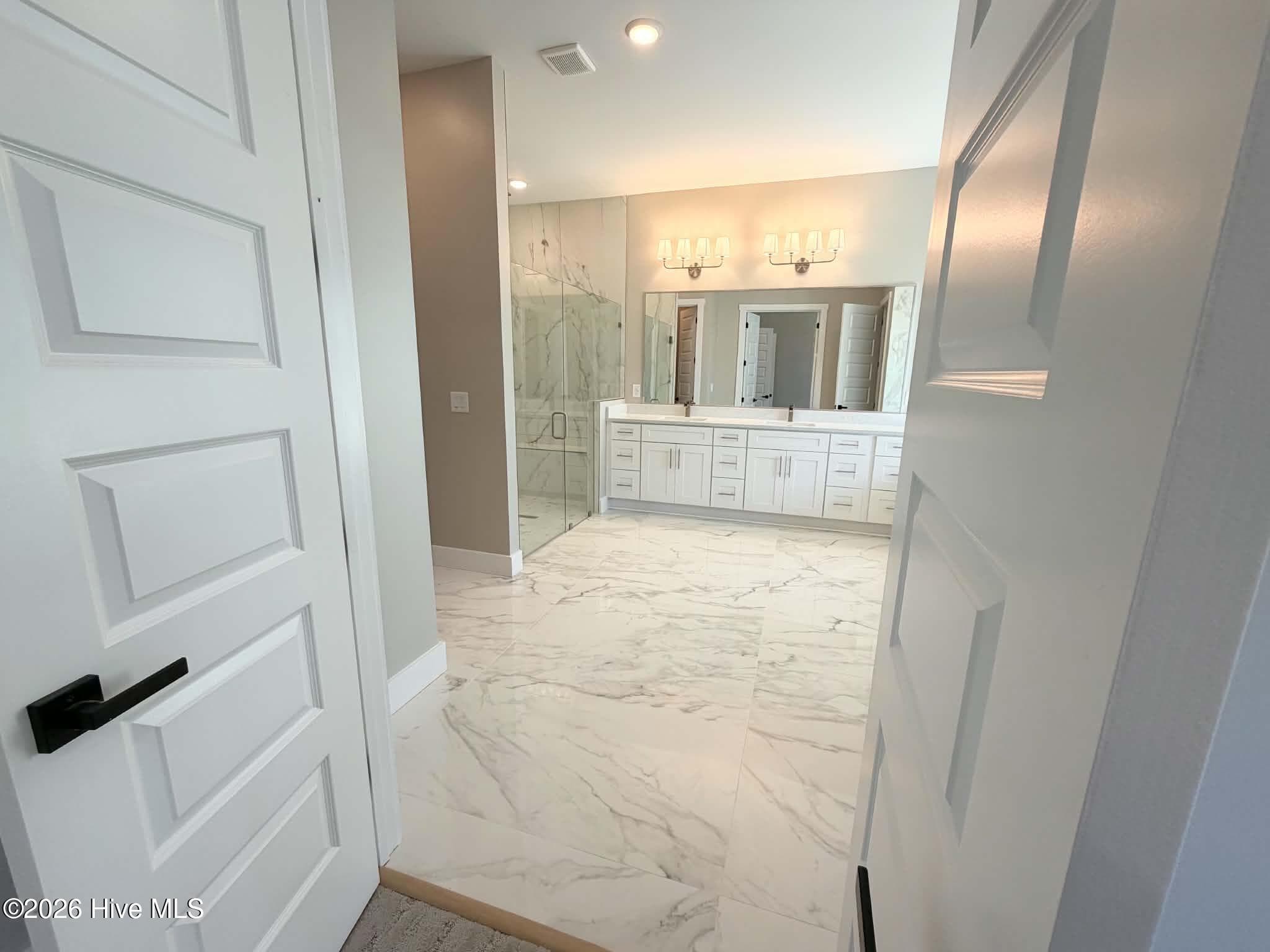 Primary bath including rain shower head, custom walk in closet, large soaking tub and custom mirrors and lighting. - 550 Glenburnie Street NW, Calabash, NC 28467