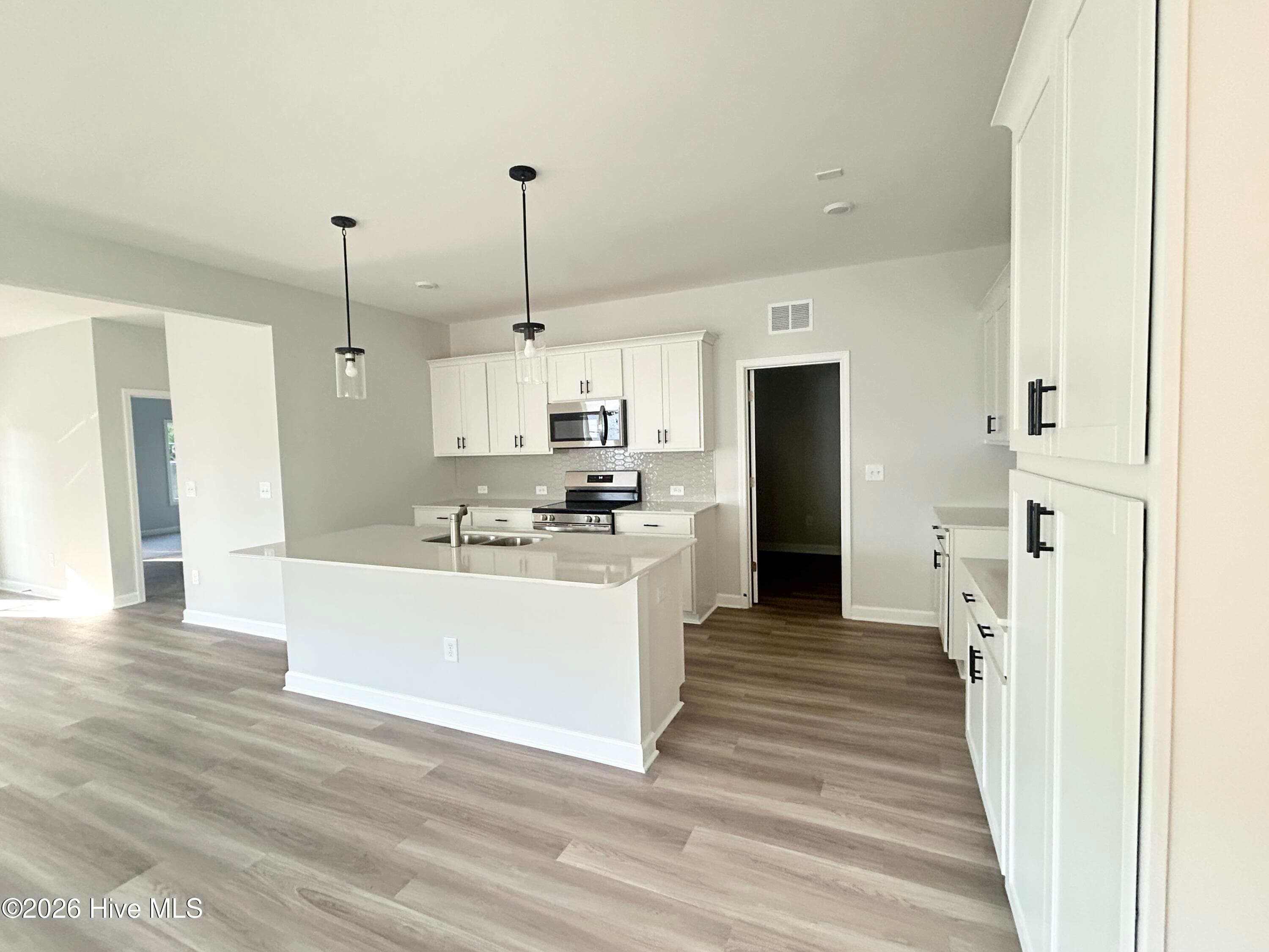 Stunning Kitchen includes Quartz Countertops, Stainless Appliances, Tile Backsplash, Beautiful Lighting fixtures and an abundance of Cabinets. - 4153 Workman Loop 68, Leland, NC 28451