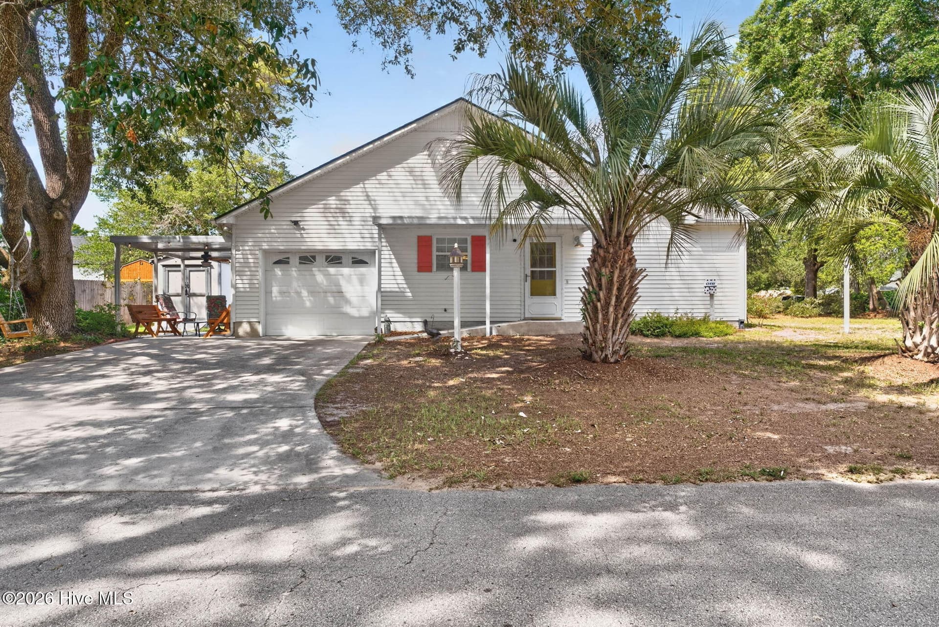Spacious driveway, attached one-car garage, and mature shade trees complement this Ocean Isle Beach mainland home. - 1650 Frink Street SW, Ocean Isle Beach, NC 28469