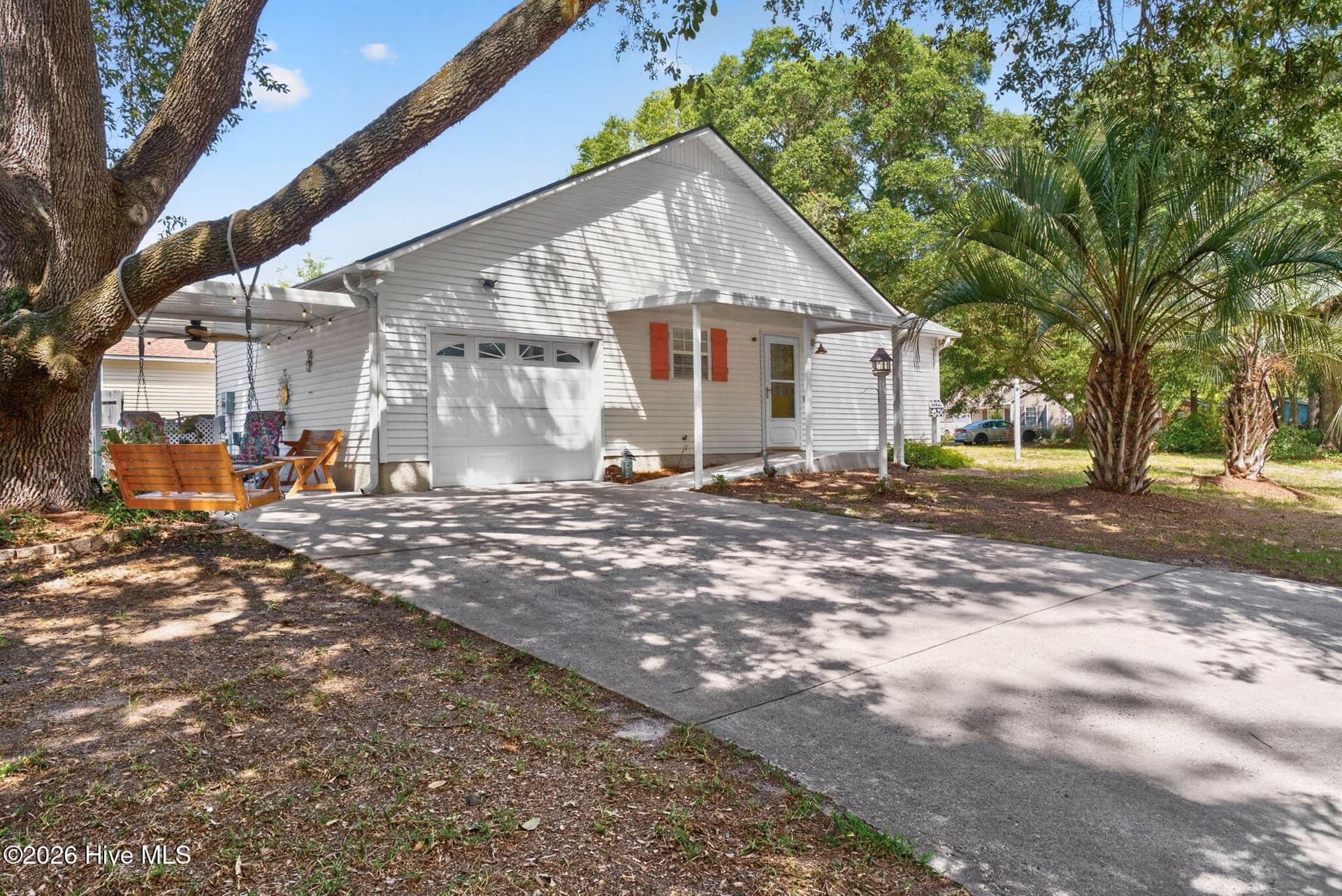 Attached garage, spacious driveway, and mature shade trees add everyday convenience to this coastal property. - 1650 Frink Street SW, Ocean Isle Beach, NC 28469