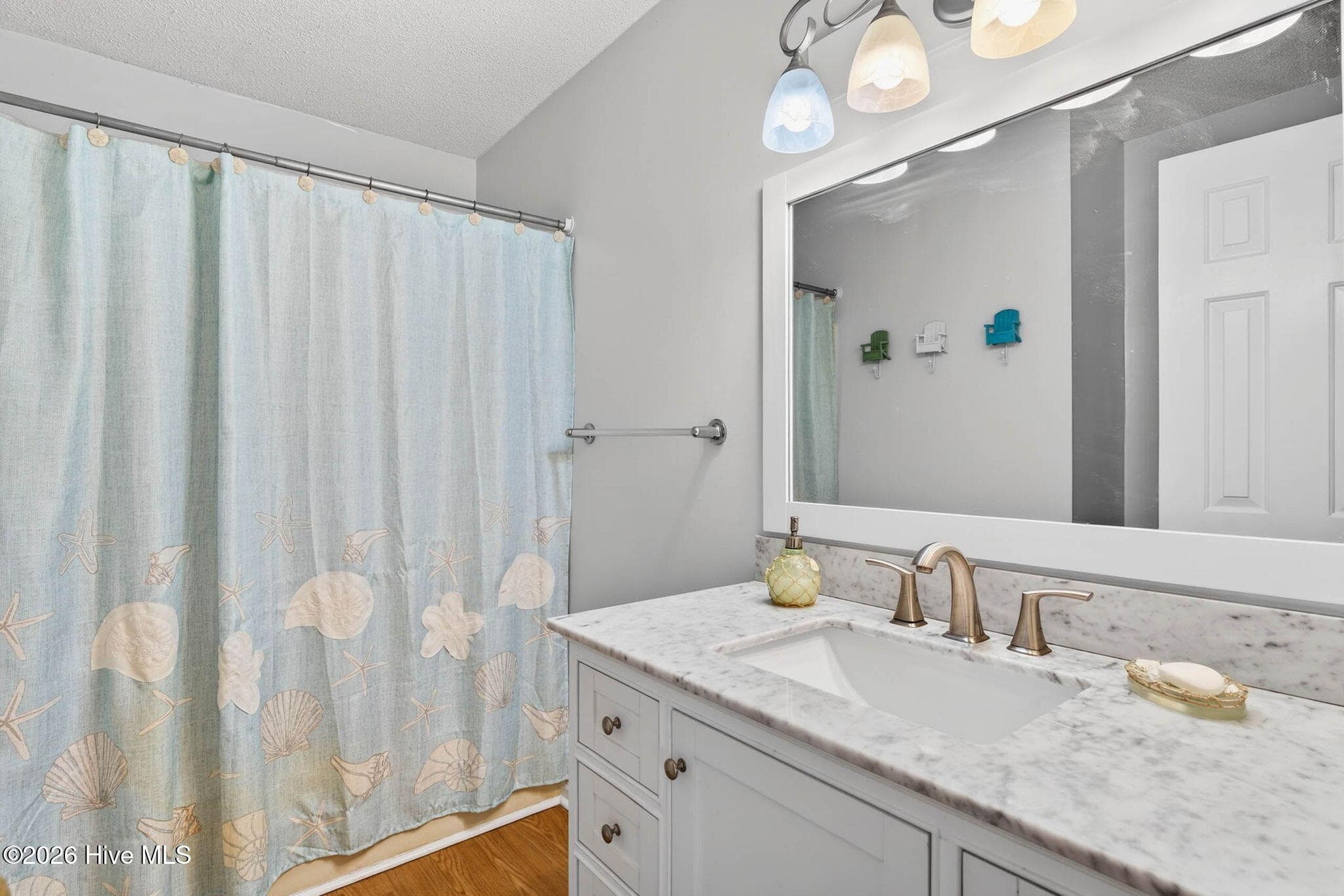 Updated bathroom with large vanity, ample counter space, and coastal finishes. - 1206 N Shore Drive W, Sunset Beach, NC 28468