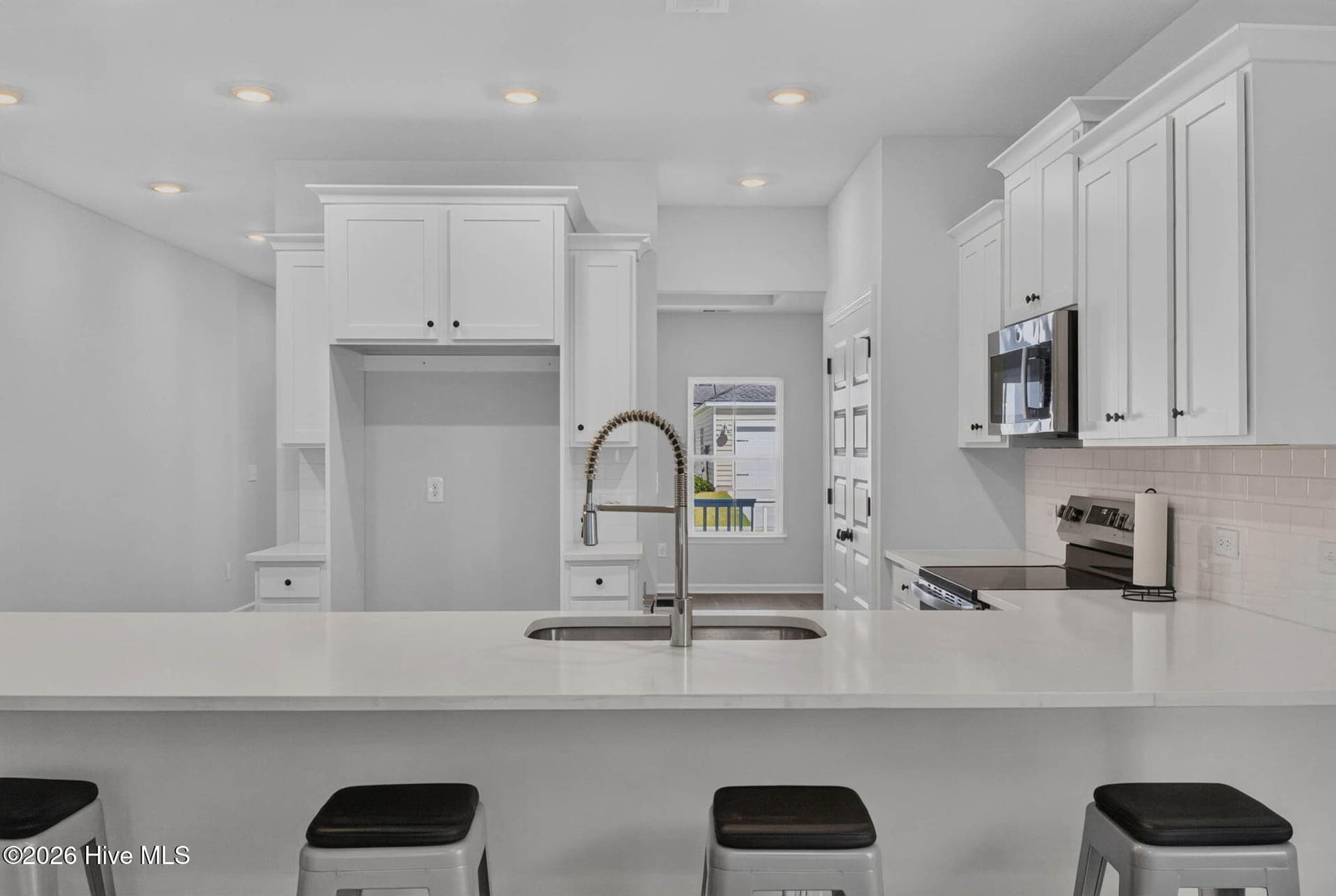 Large kitchen island with seating, stylish pendant lighting, and an open layout ideal for entertaining. - 3447 Sandhill Crane Drive SW, Ocean Isle Beach, NC 28469