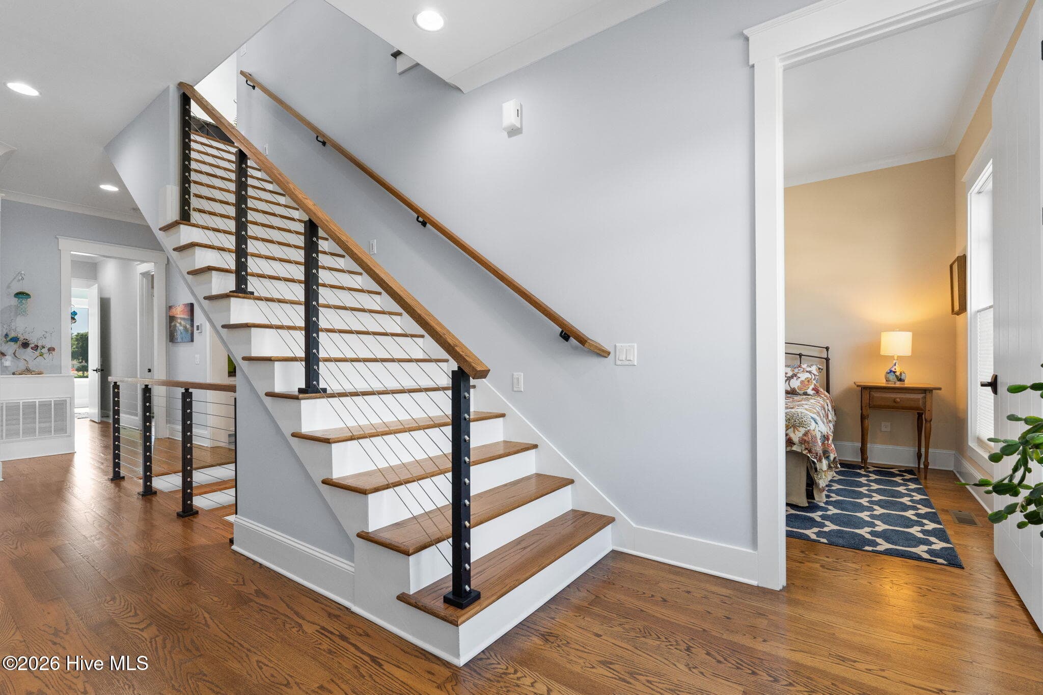 Wire cabled staircase with red oak steps matching red oak throughout home - 2775 Long Bay Drive SE, Southport, NC 28461
