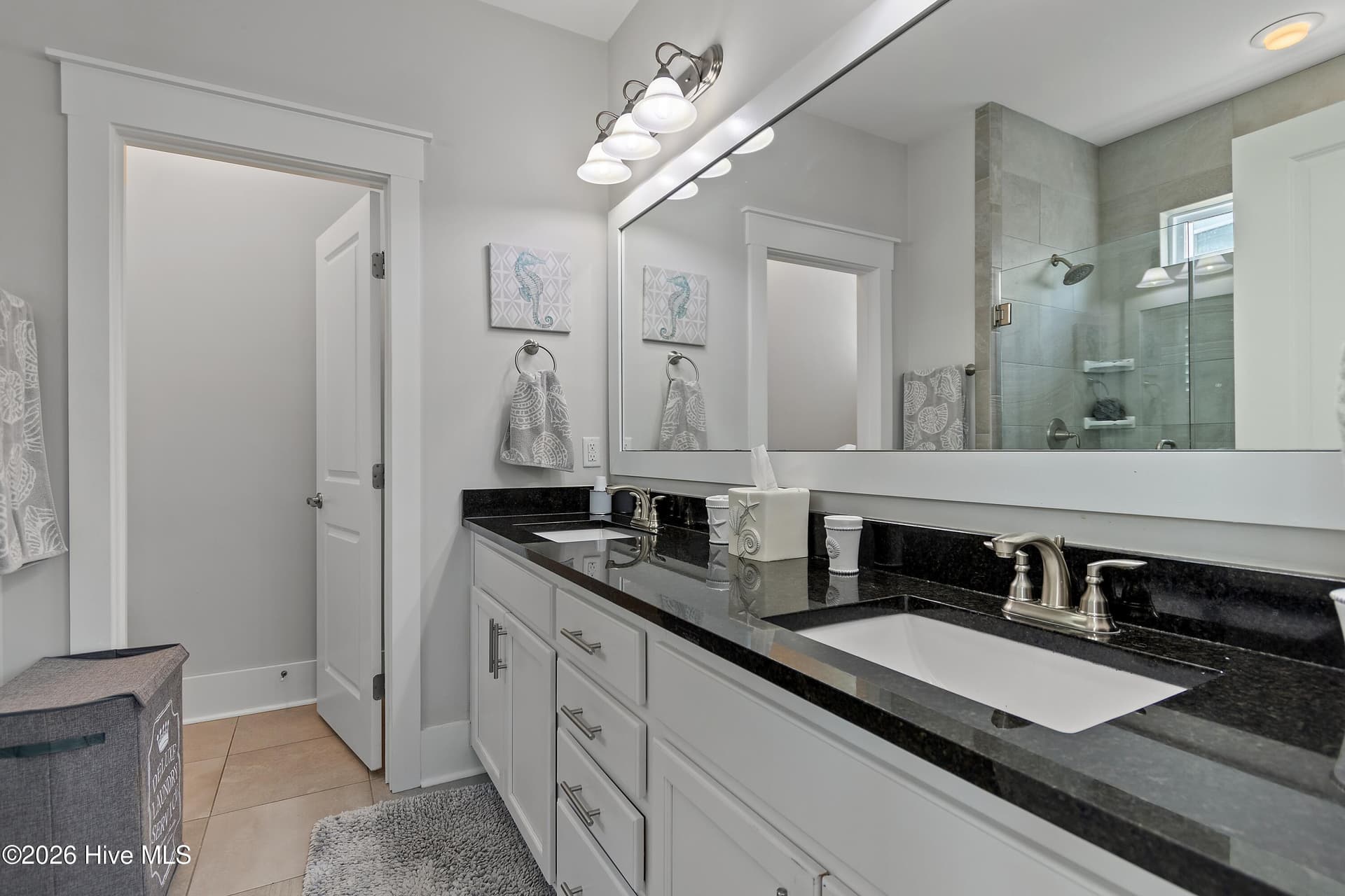 Primary bathroom with dual vanities and water closet for privacy. - 6358 Bryson Drive SW, Ocean Isle Beach, NC 28469