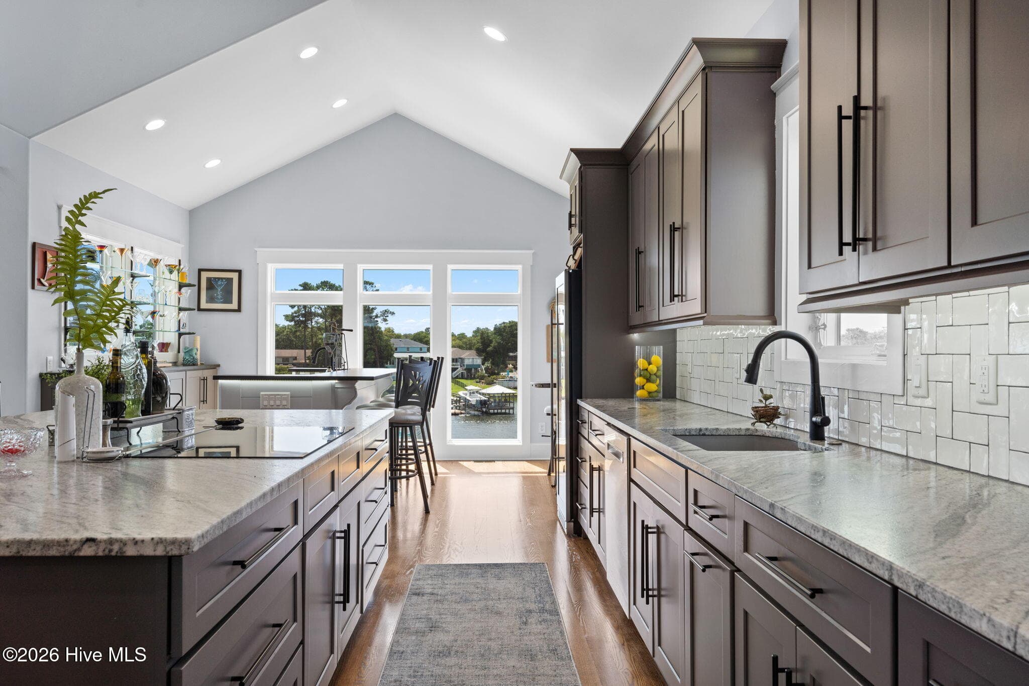 Honed granite countertops with tile backsplash and composite sink with black fixtures - 2775 Long Bay Drive SE, Southport, NC 28461