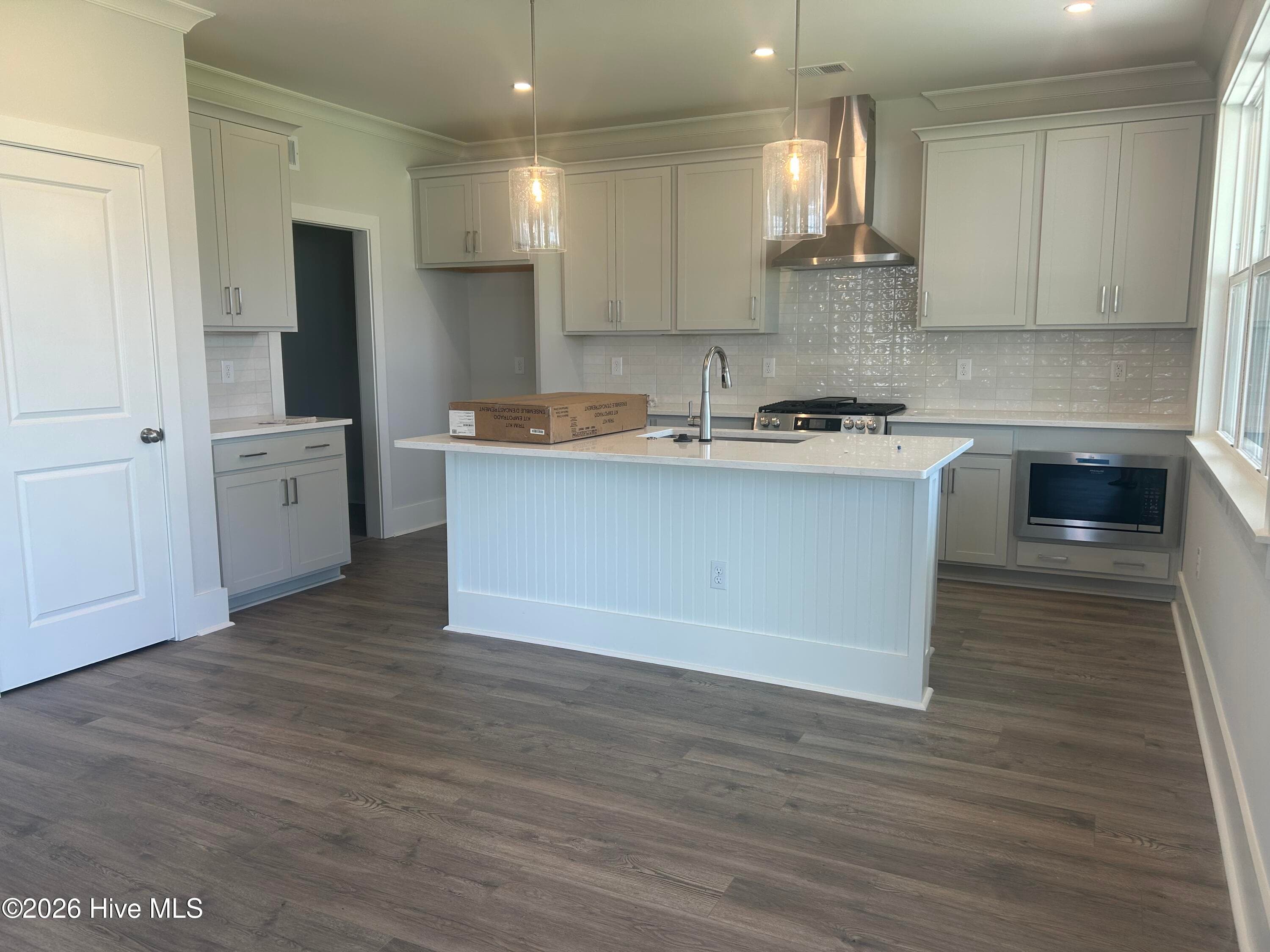 Kitchen with stainless steel gas range, vent hood, microwave and dishwasher. Quartz Countertops and 42" upper cabinets. - 5202 Moonshell Loop, Wilmington, NC 28412