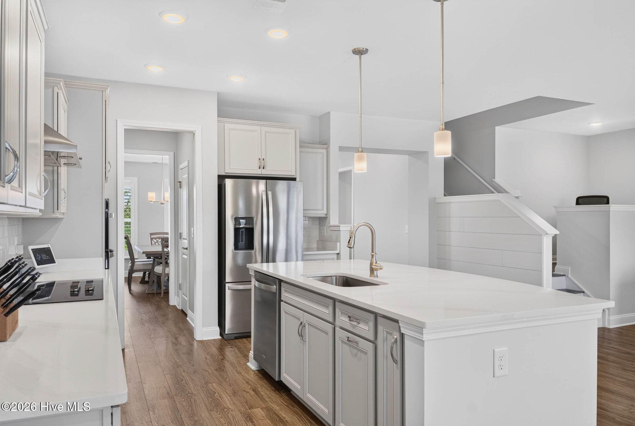 The open kitchen features a large center island with seating, solid-surface countertops, and abundant storage. - 139 Eagle Claw Drive, Calabash, NC 28467