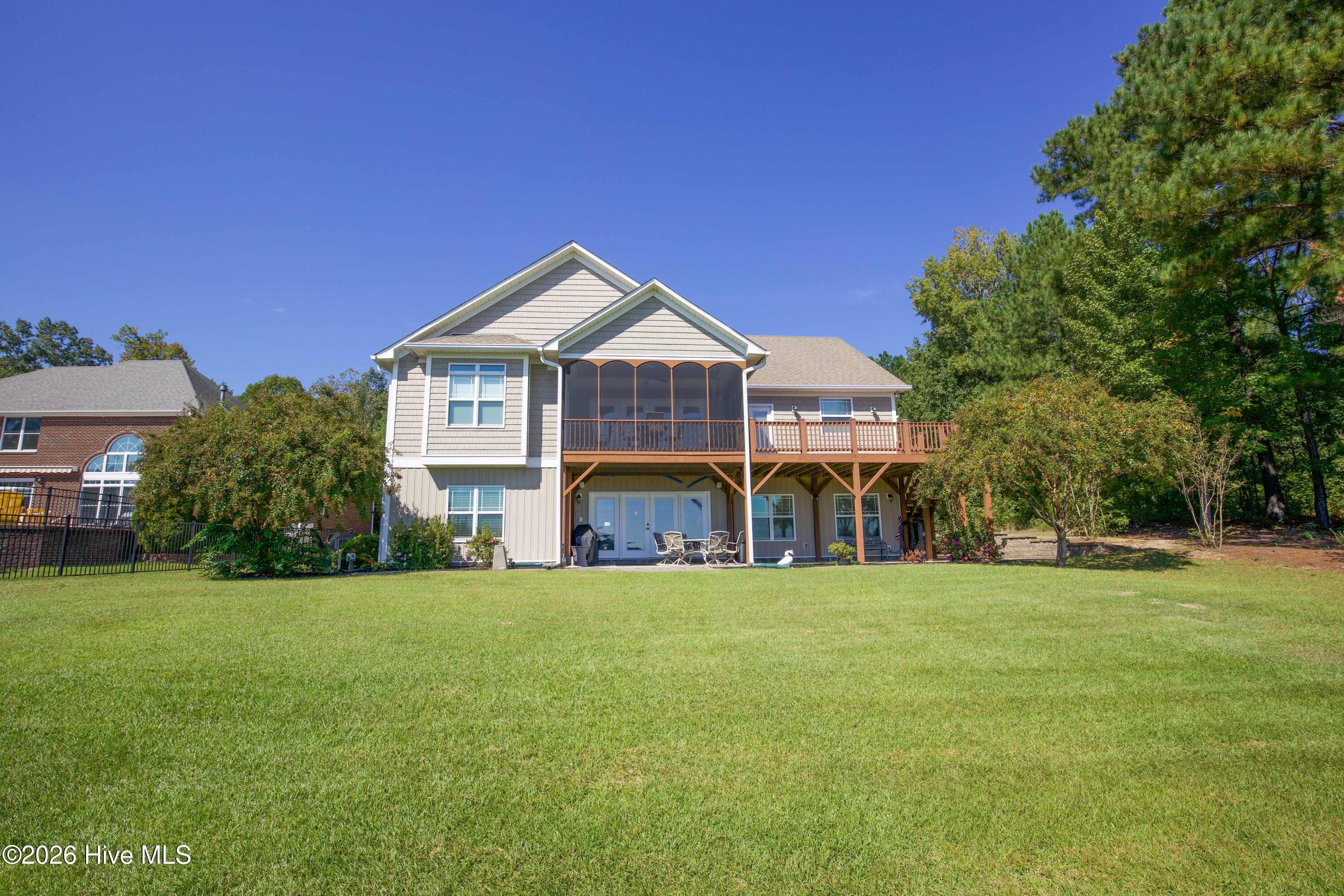 Rear of the home with the screened porch, open deck, and covered walkout patio. - 899 Seagull Drive, Vass, NC 28394, Vass