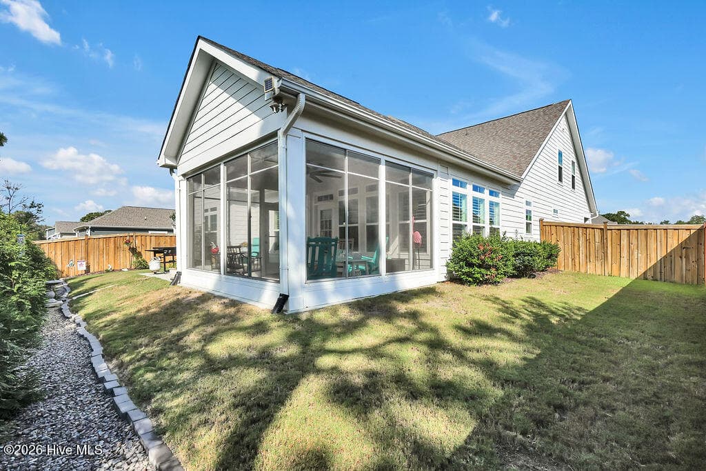 With its extended patio and enclosed 3-season room, this irrigated, beautifully landscaped sloping backyard is easy to maintain. - 142 Rice Marsh Way, Wilmington, NC 28412