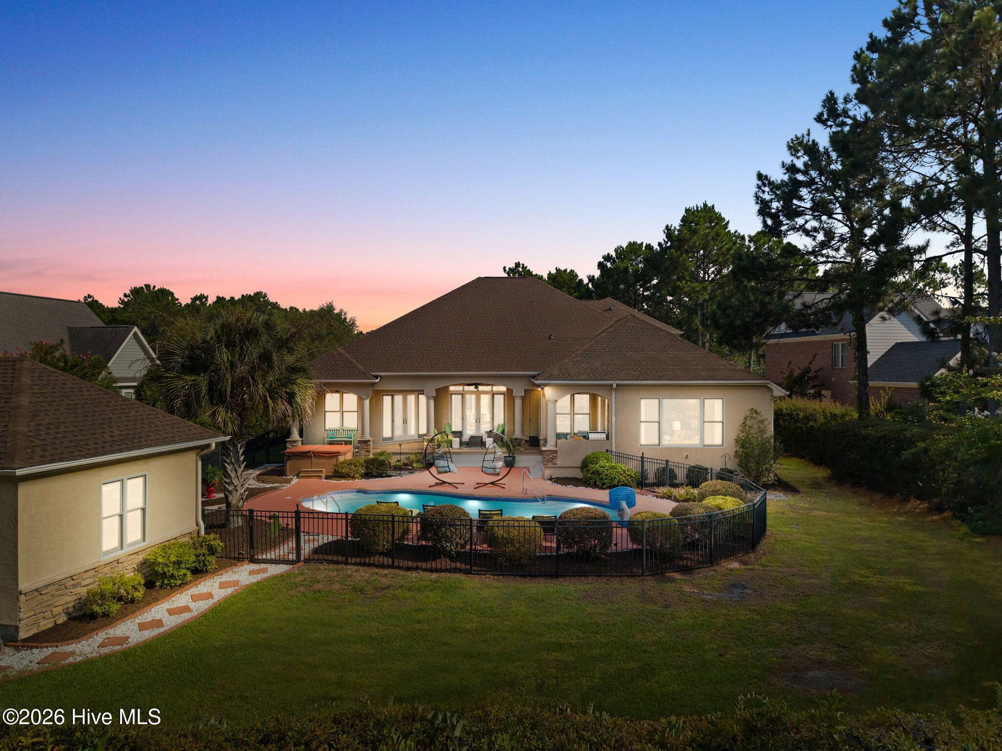 Back of house at twilight shows pool and cabana - 3858 Ridge Crest Drive, Southport, NC 28461