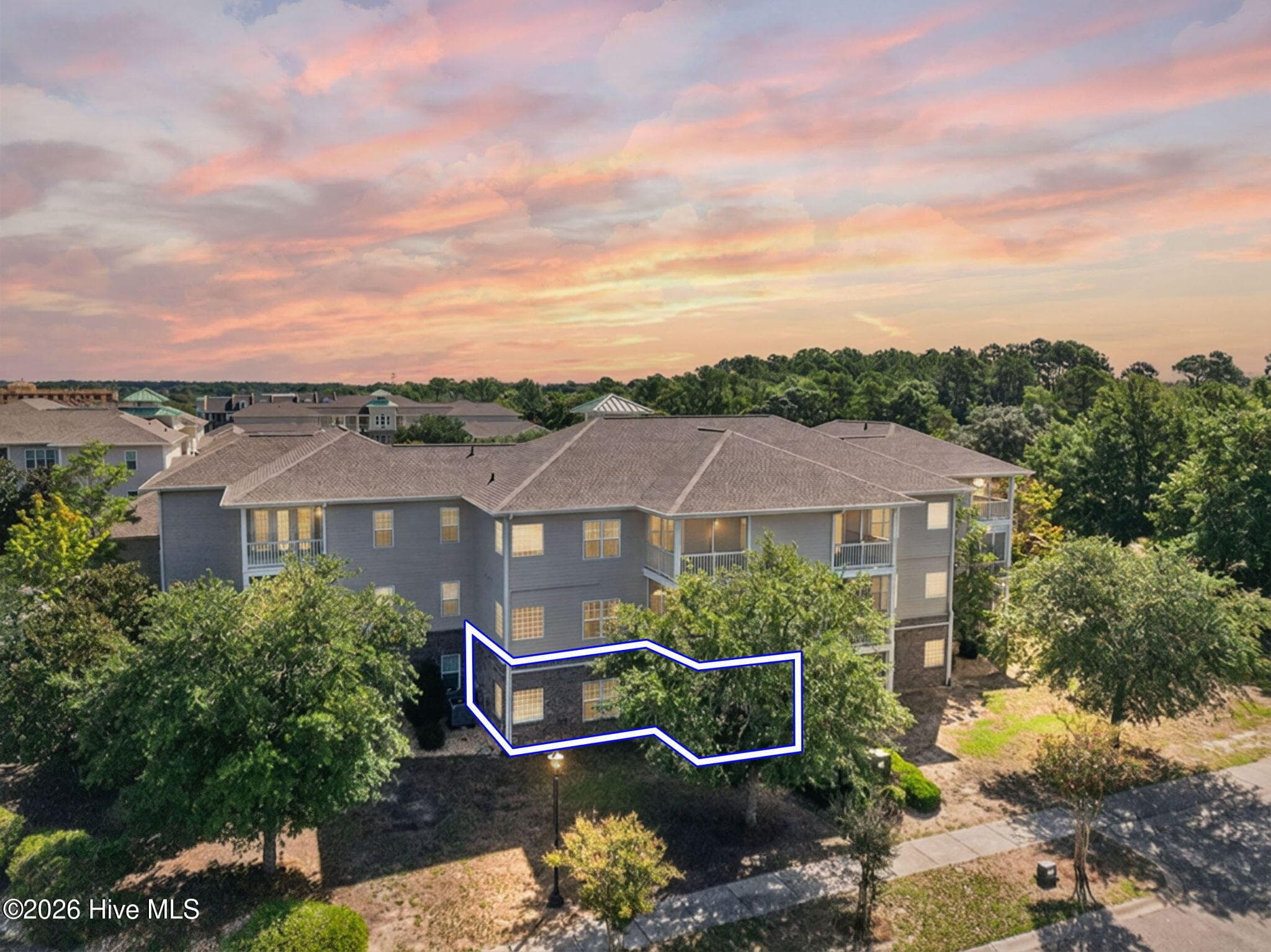 Back view of condo building, showing ground floor unit and screened porch - 7825 High Market Street #303, Sunset Beach, NC 28468