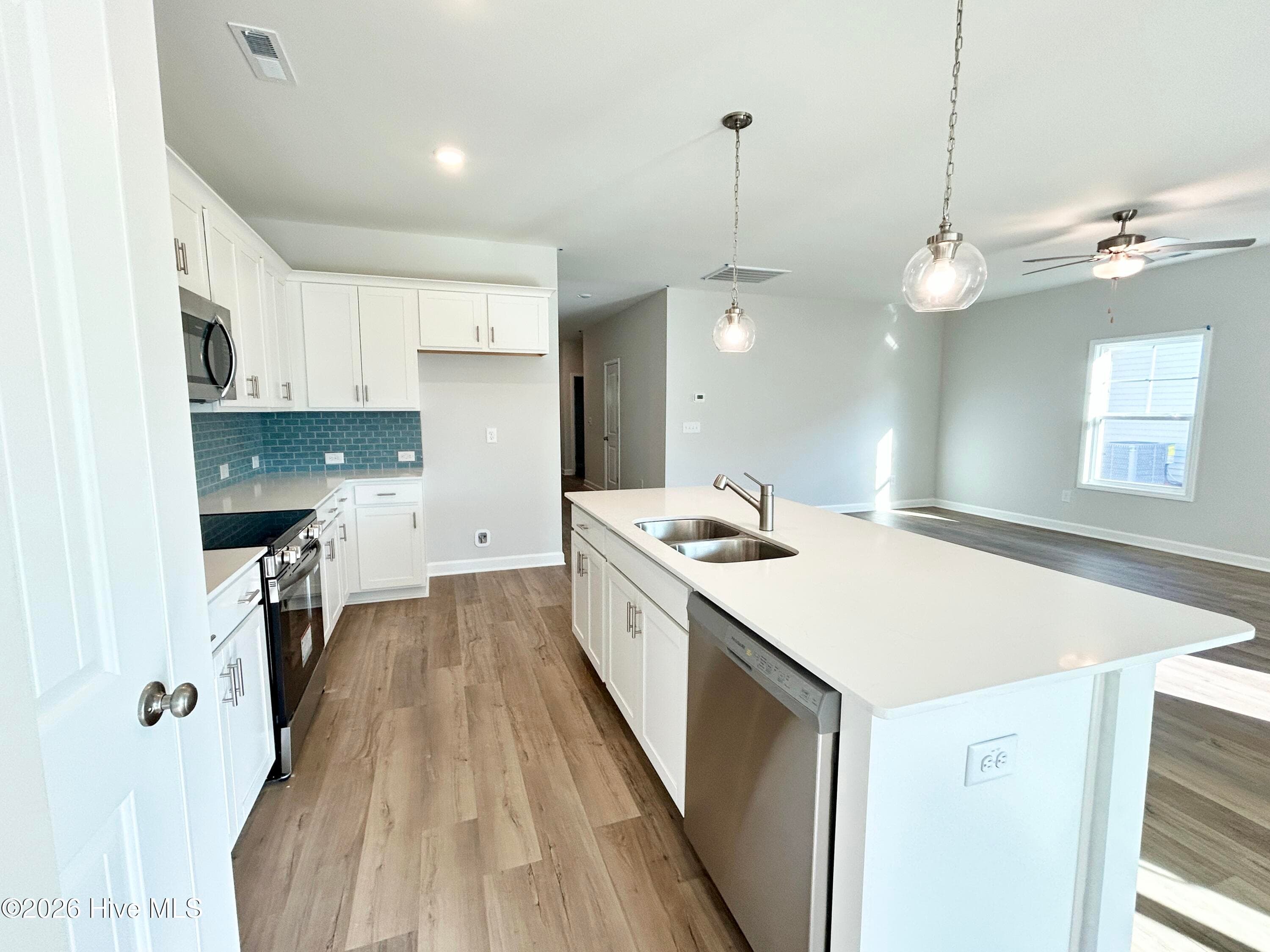 Elegant Kitchen includes Quartz Countertops, Stainless Appliances, Tile Backsplash, and Beautiful Lighting fixtures. - 4149 Workman Loop 67, Leland, NC 28451