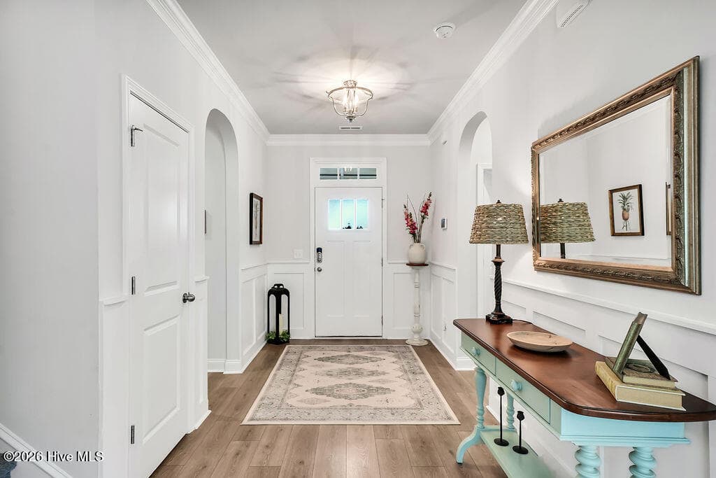 A wide foyer transitions into an open great room consisting of a large living room, enormous kitchen, and dining area. - 142 Rice Marsh Way, Wilmington, NC 28412