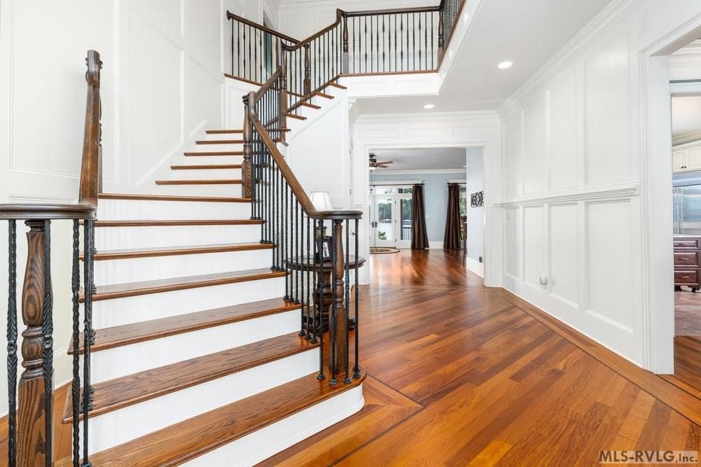 Grand Staircase, Beautiful wide-plank Brazilian hardwood floors paired with elegant wainscoting. - 381 West Bend Dr., Gasburg VA 23857, Gasburg