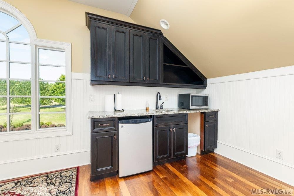 Sleek Wet Bar, Elevate your hosting game with espresso-toned cabinetry and premium countertops, perfectly designed for entertaining with a built-in fridge and wet bar. - 381 West Bend Dr., Gasburg VA 23857, Gasburg