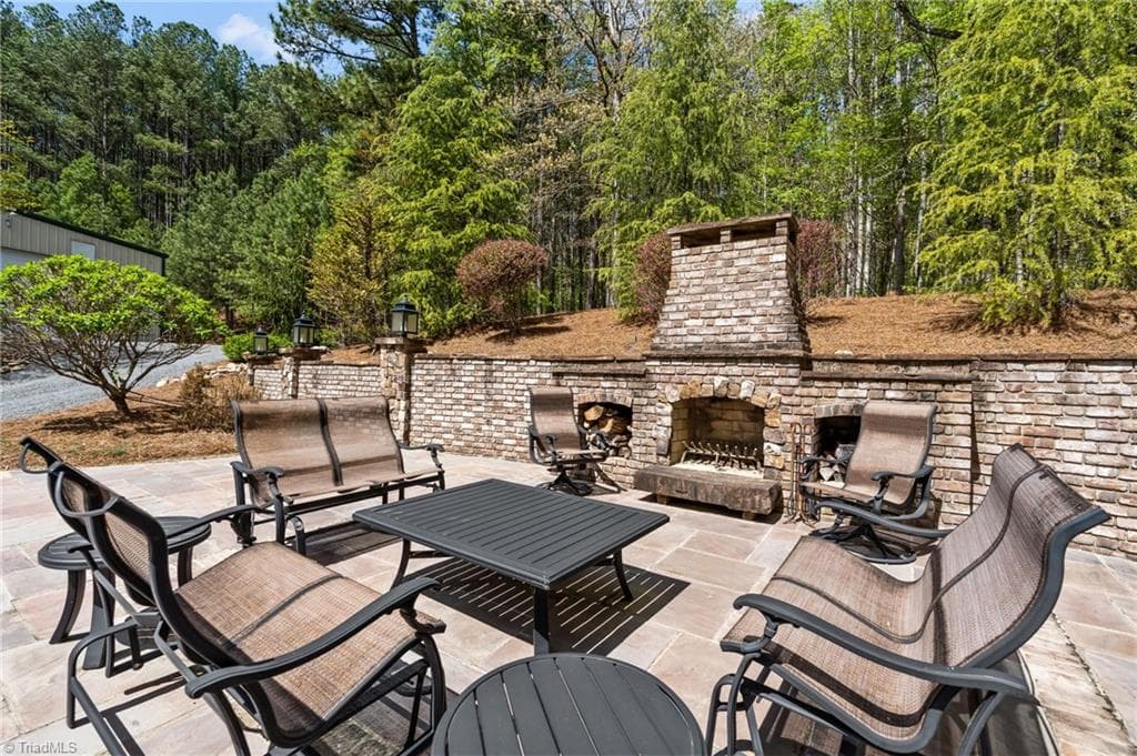 The outdoor brick fireplace and spacious bluestone patio are perfect for quiet evenings or large gatherings! - 11555 Double Spring Road, Lewisville NC 27023, Lewisville