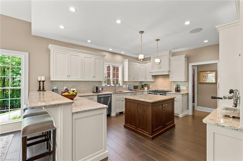 Thoughtfully renovated kitchen with quartz countertops, custom cabinets, bar seating, and pendant lighting - 11555 Double Spring Road, Lewisville NC 27023, Lewisville