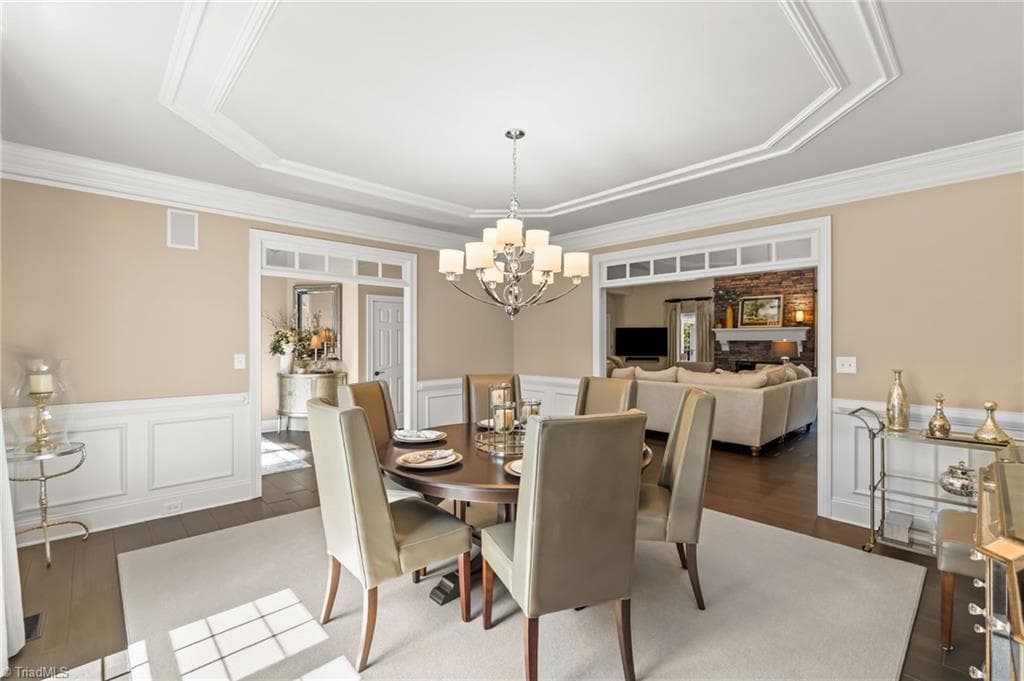 Every guest has a view when entertaining in this lovely dining room with wainscoting and oversized passthroughs - 11555 Double Spring Road, Lewisville NC 27023, Lewisville