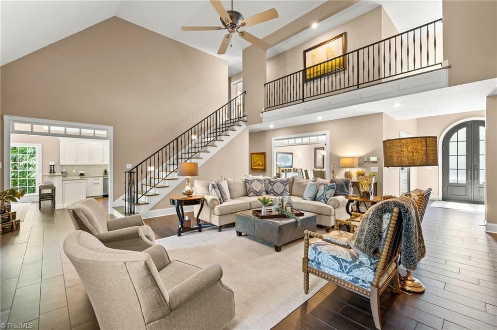 Soaring vaulted ceilings and oversized windows with a custom iron railing to the open 2nd floor balcony - 11555 Double Spring Road, Lewisville NC 27023, Lewisville