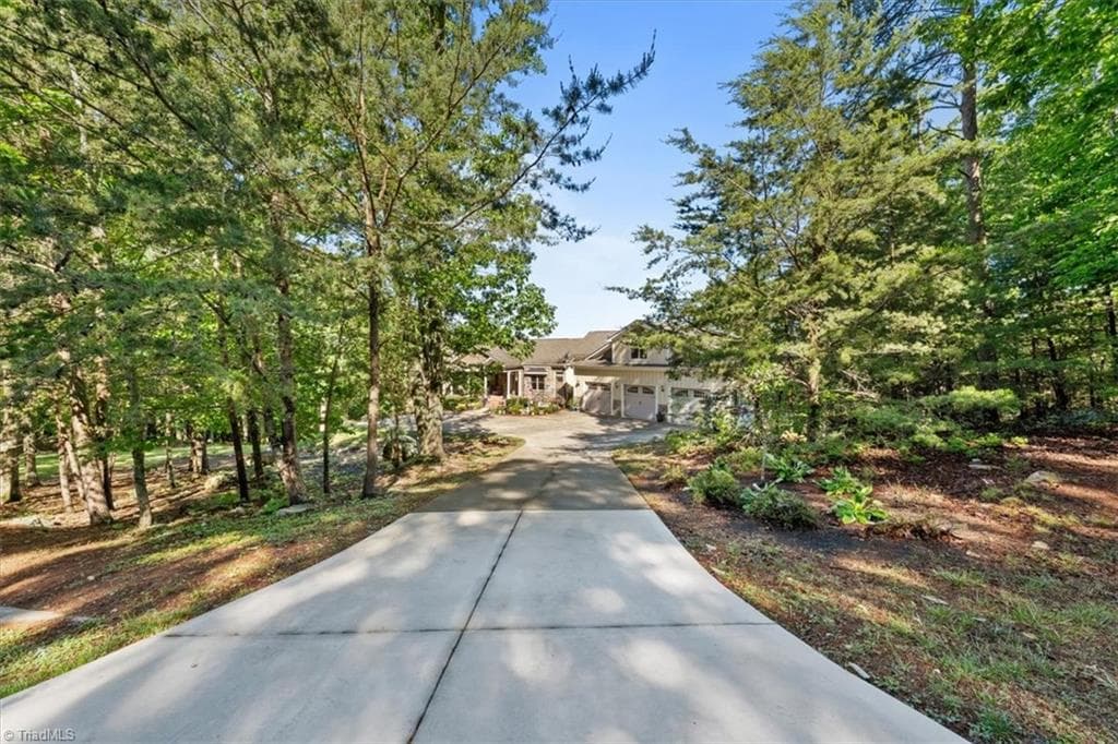 Wide front approach showcasing the home’s private setting, generous parking, and custom design - 2207 Sierra Trace Road, Denton NC 27239, Denton