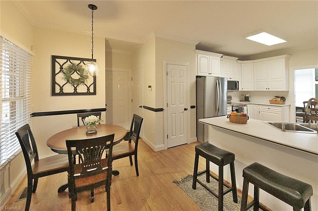 Bright, open-concept kitchen featuring solid surface countertops with extra seating, perfect for entertaining and staying connected. - 1101 Clyde Edgerton Drive, Kernersville NC 27284, Kernersville