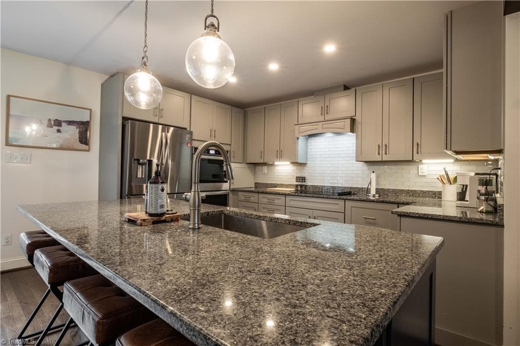 Kitchen features island and granite countertops. Photo taken 2025. - 629 Oakland Drive, Elkin NC 28621, Elkin