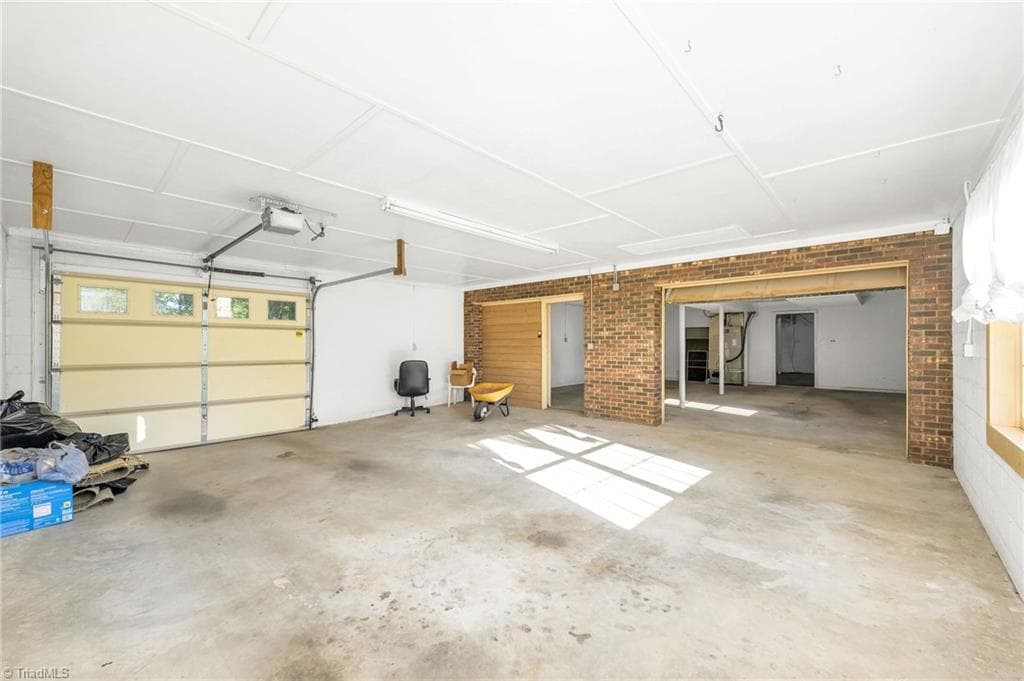 Looking from the garage to the 2nd room with an entrance door and garage door. The first room of the garage is at the back. - 196 Lewis Fork Drive, Wilkesboro NC 28697, Wilkesboro