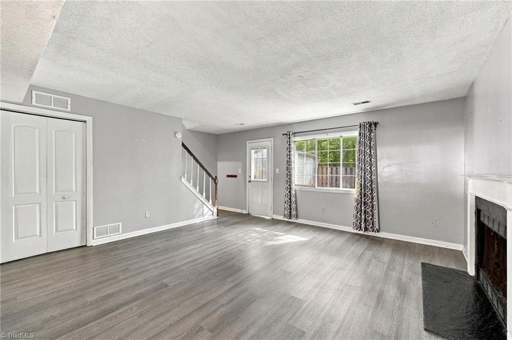 Living area with view of the door to the utility room on the main floor. - 5500 Richland Street # A, Greensboro NC 27409, Greensboro