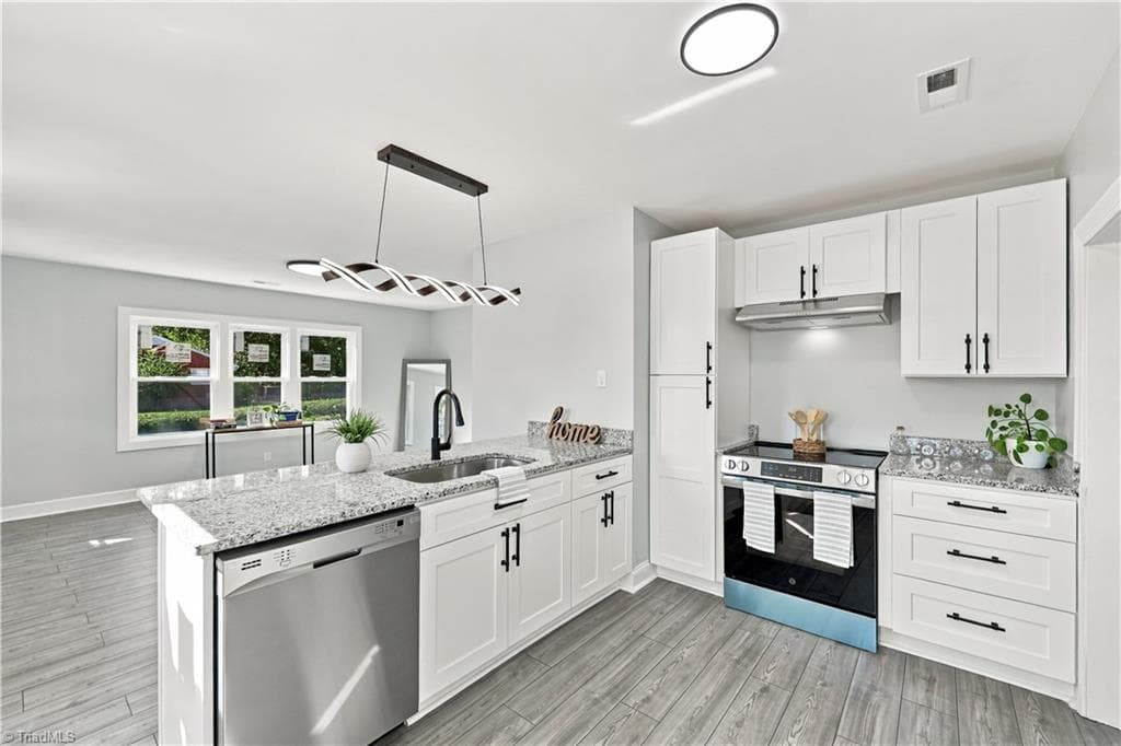 Kitchen with granite countertops, with a dimmable light fixture. - 1113 Benjamin Benson Street, Greensboro NC 27406, Greensboro