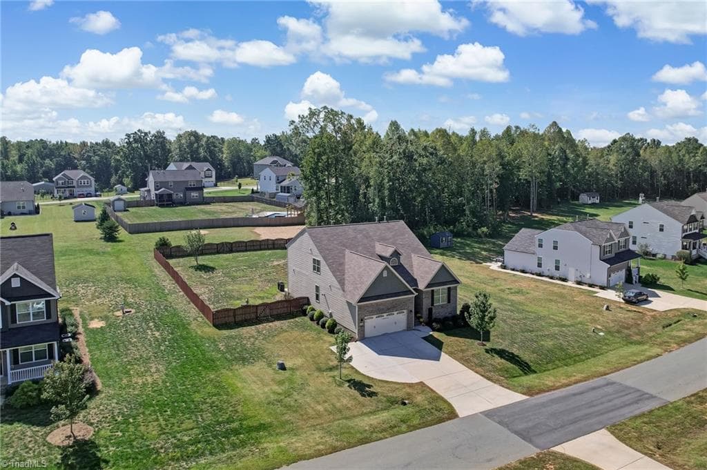 The large fenced backyard provides plenty of usable outdoor space, with additional acreage extending beyond the rear fence - 1466 Kernodle Landing Drive, Burlington NC 27217, Burlington