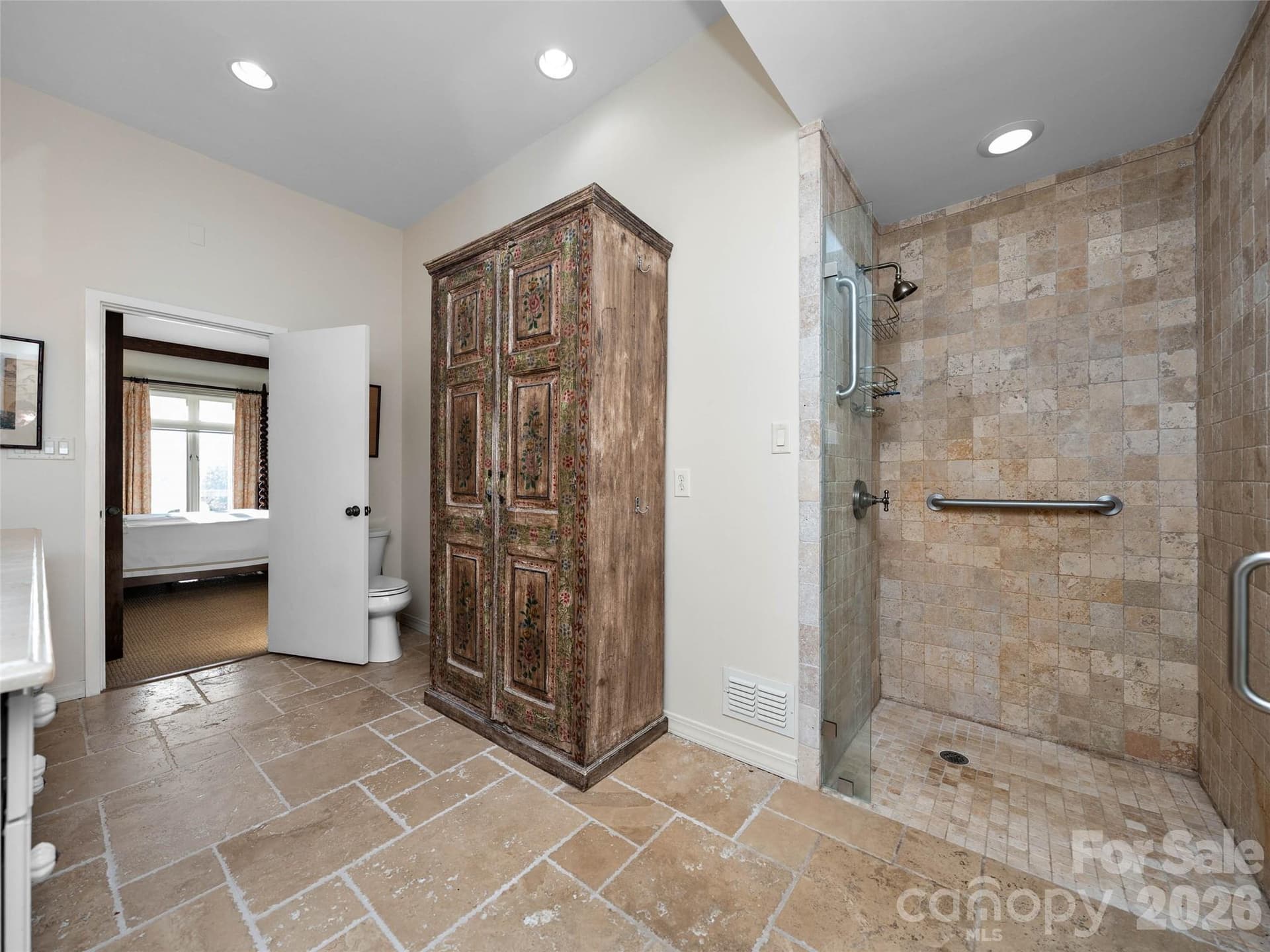 Stone tile floors, double vanities, and refined finishes create a peaceful, timeless bath. - 65 Crestwood Road, Asheville
