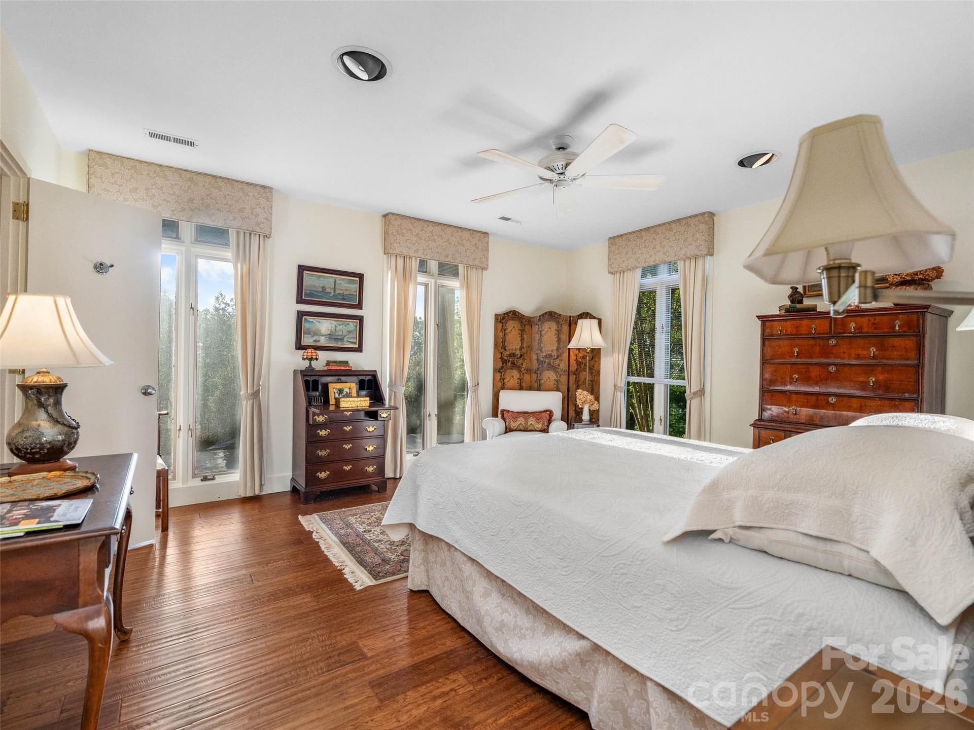Floor-to-ceiling windows surround this serene bedroom, filling the space with natural light and garden views. - 65 Crestwood Road, Asheville