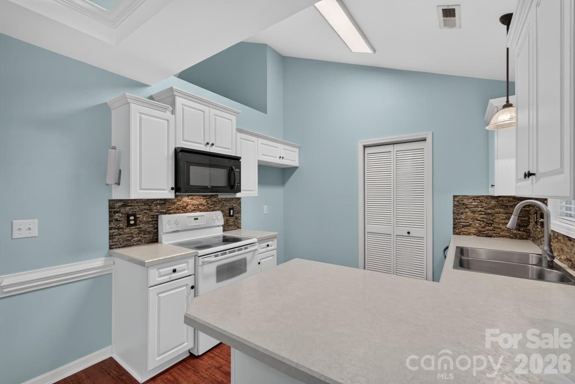 Abundant cabinet storage, black appliances, and bright task lighting make meal prep enjoyable. - 702 Painted Lady Court, Rock Hill