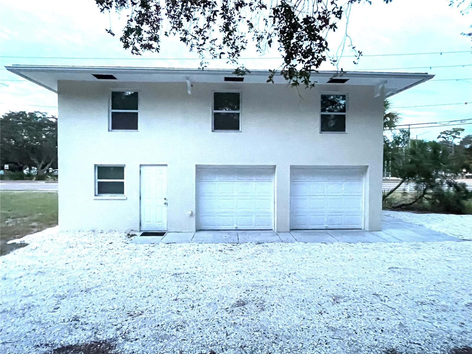 South side of the house. Pedestrian door on left is access to the 3rd bedroom/guest suite/home office w/full bath. - 5370 71ST ST N, ST PETERSBURG