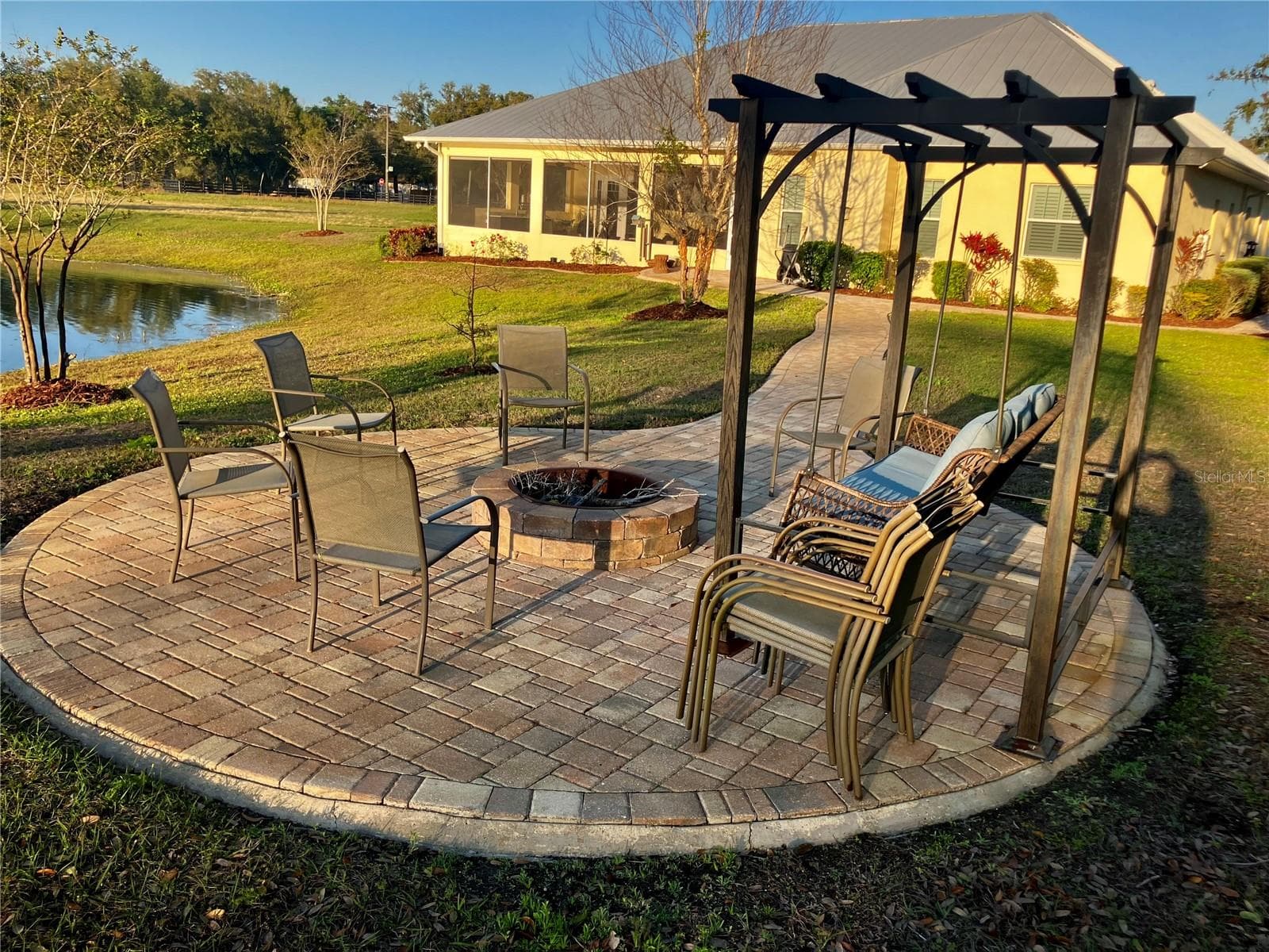 Fire pit seating with swing overlooking pond - 3709 GALLAGHER RD, PLANT CITY