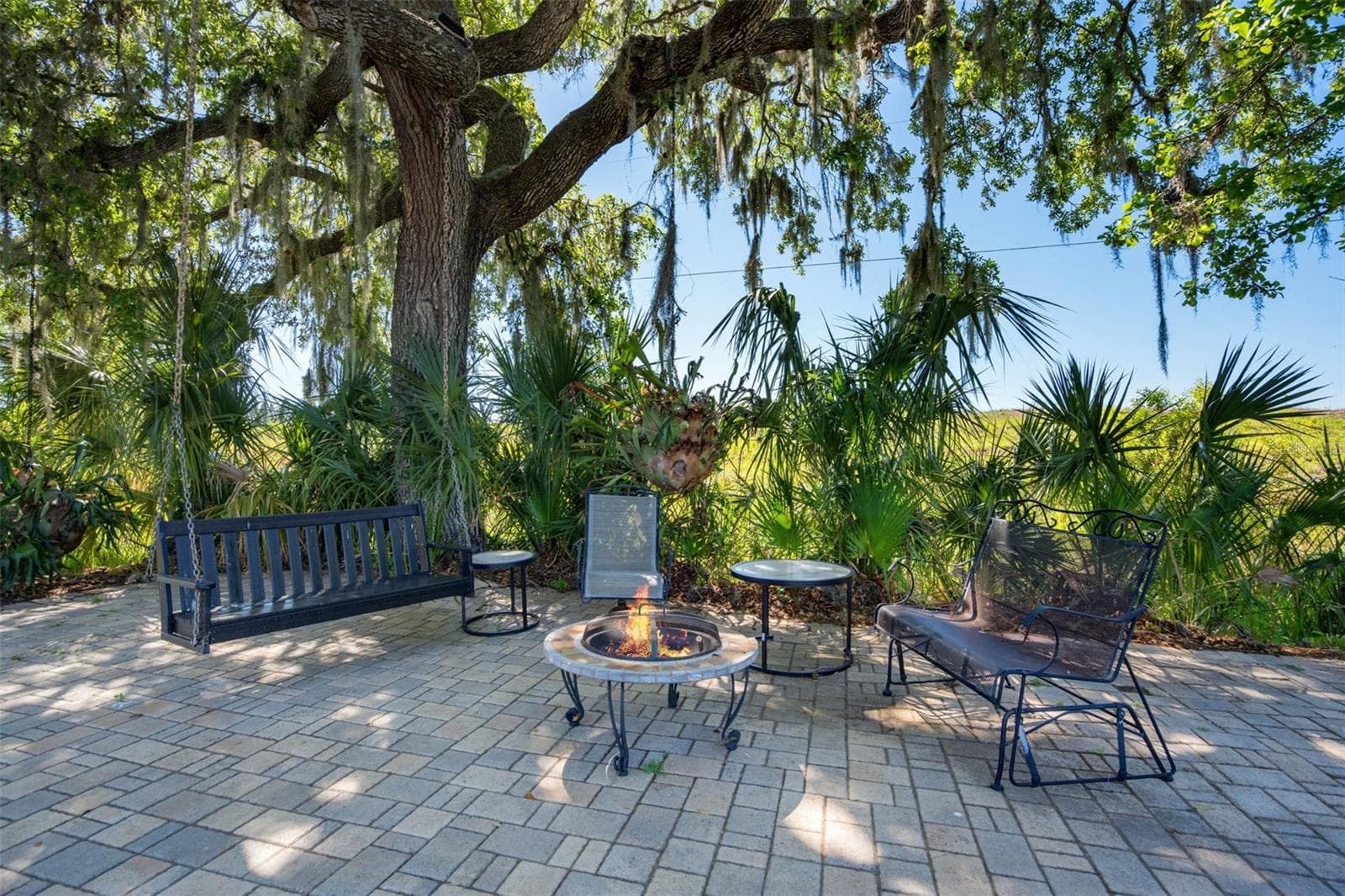 West side patio with swing and fire pit with virtual fire - 701 E 60 HWY, PLANT CITY