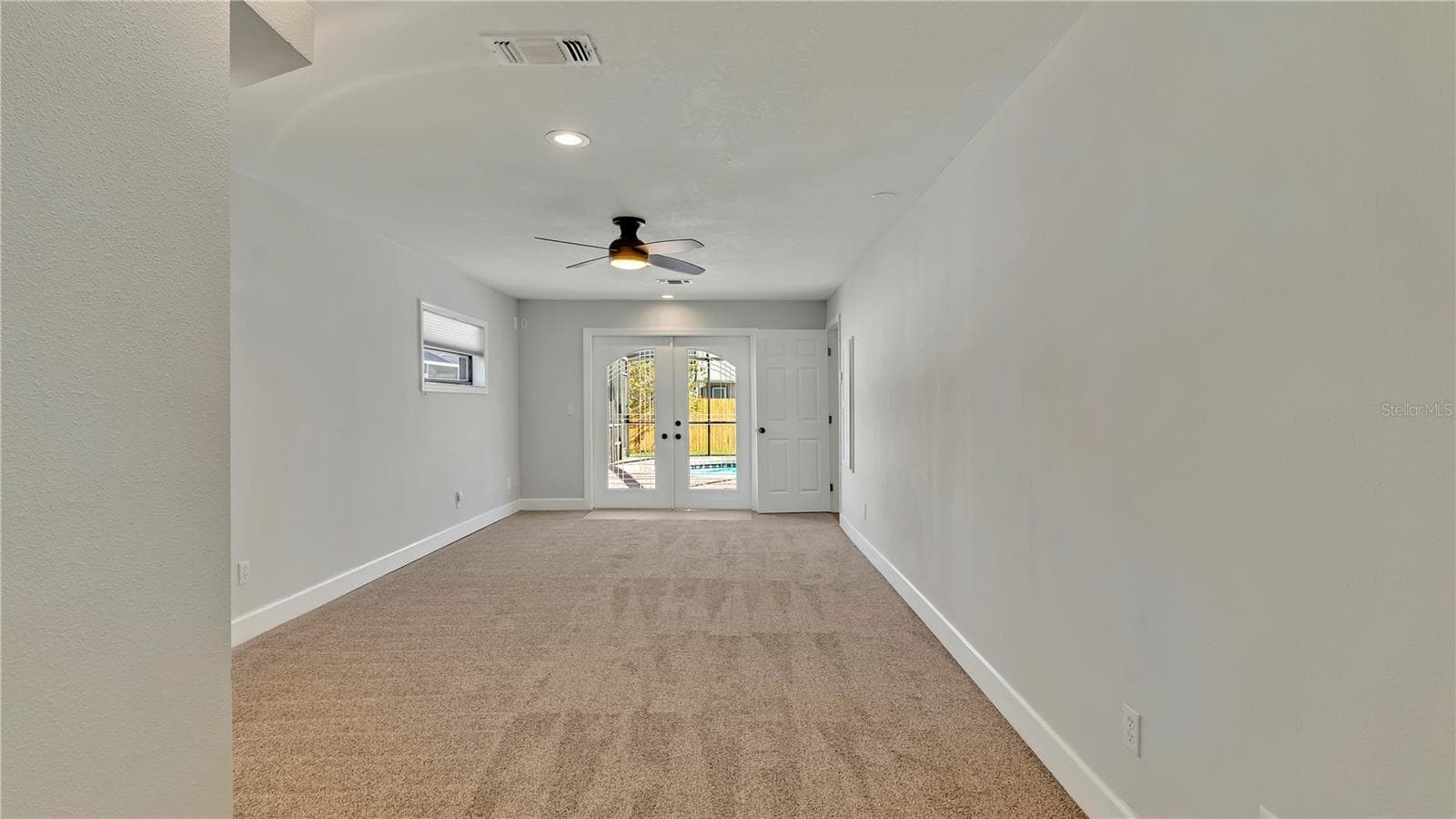 Primary Bedroom (12x26) looking towards the French Doors going to the screened in pool area - 7801 17TH WAY N, ST PETERSBURG