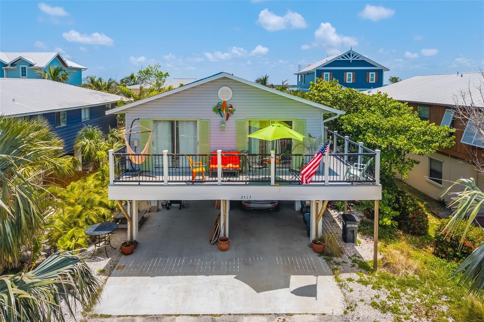 Bright coastal exterior with generous deck space, perfect for enjoying the island lifestyle. - 2513 AVENUE B #B, BRADENTON BEACH