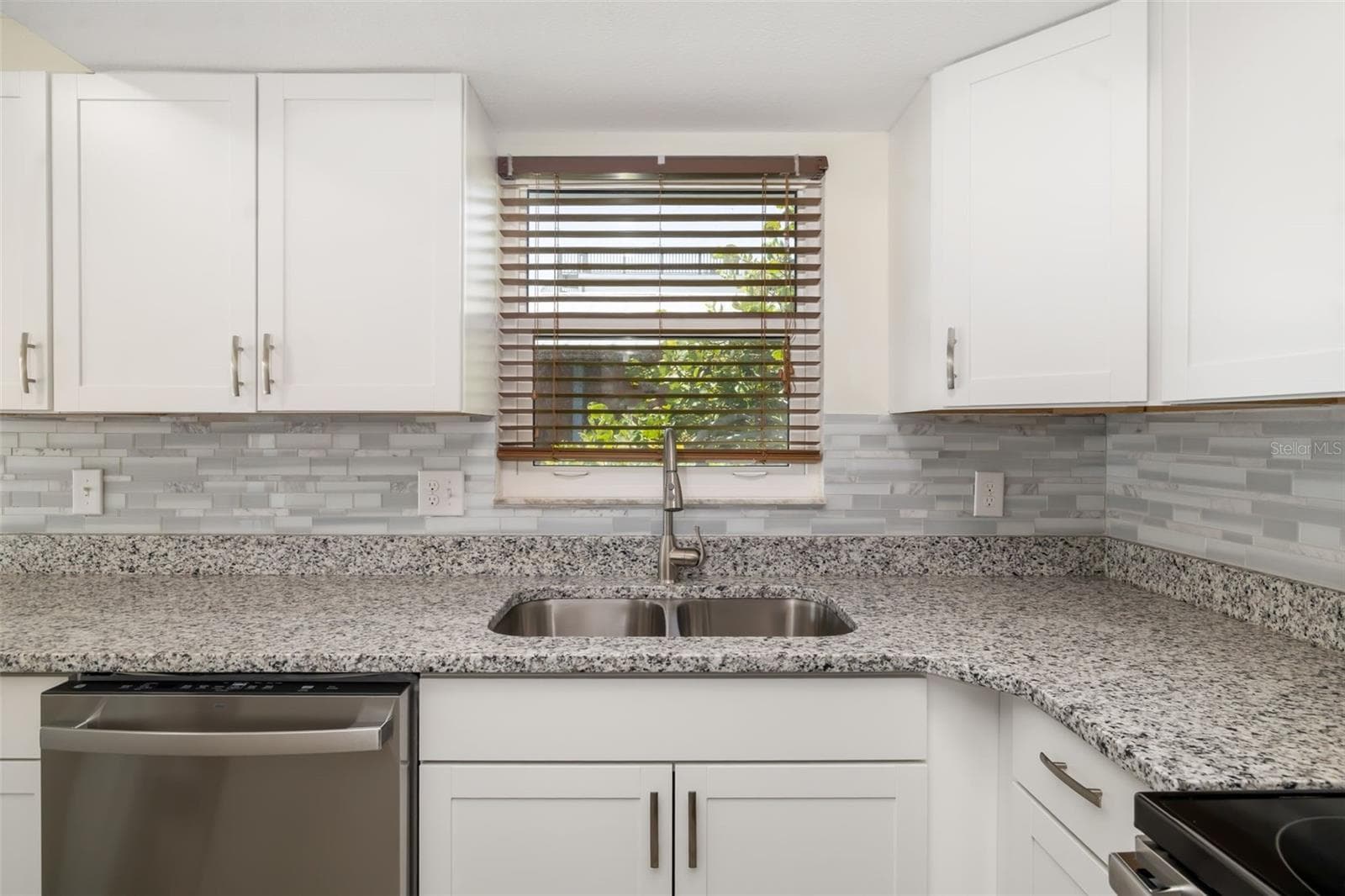 Kitchen window provides natural light while overlooking the outdoor space.Bright kitchen with window over sink bringing in natural light and garden views. - 2513 AVENUE B #B, BRADENTON BEACH
