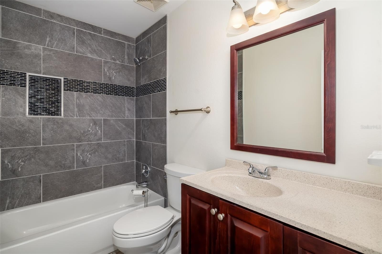 Bathroom – Tub/Shower ComboUpdated bathroom with tile surround and modern finishes. - 2513 AVENUE B #B, BRADENTON BEACH